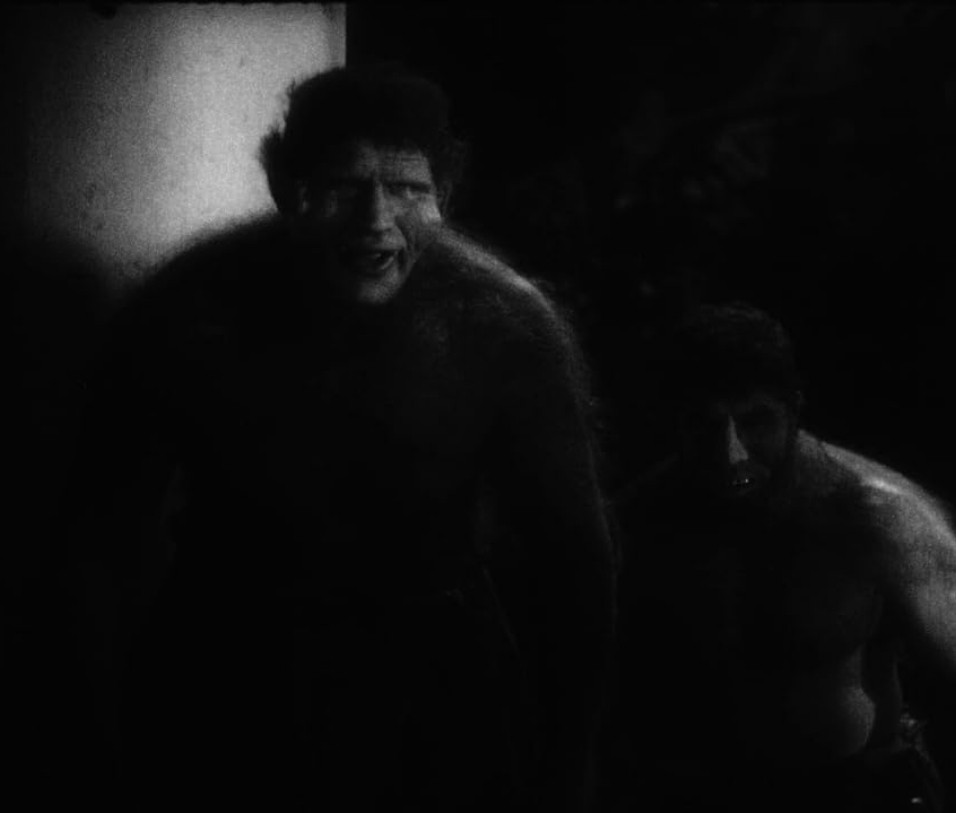 two monstrous men, their bodies obscured by shadows