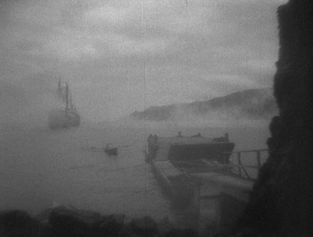 an image of a dock and a ship in the water, very foggy out