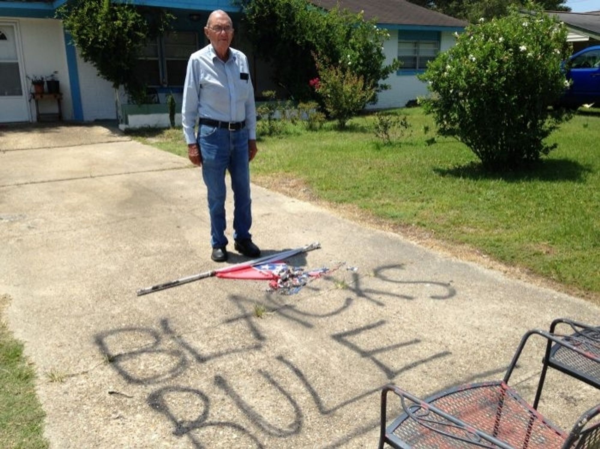 White Mississippi man glaring defiantly while standing over the "BLACKS RULE" graffito on his driveway that he definitely didn't spray-paint himself