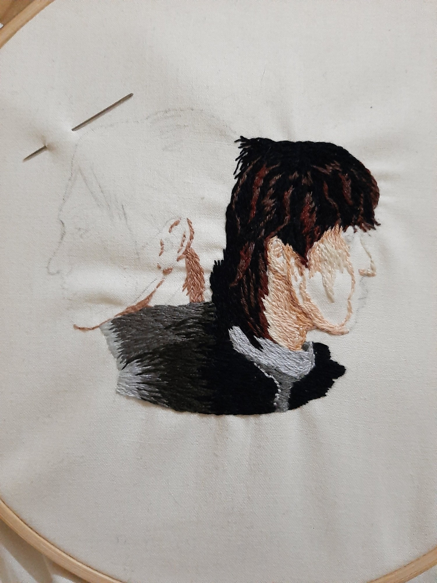 Work in progress photo of an embroidery of Jun and The8 from SEVENTEEN, back to back in profile. The8 is almost complete, Jun is just being started.