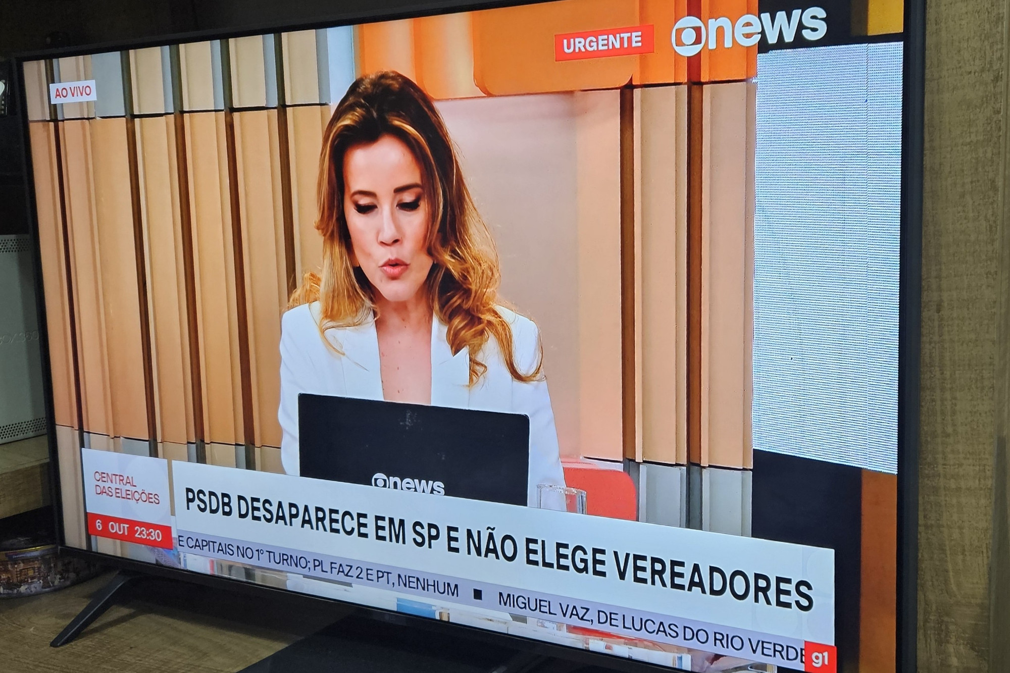 Foto da TV sintonizada na GloboNews, com a Natuza Nery lendo uma notícia no laptop. 

No GC, em maiúsculas, está escrito: 
PSDB DESAPARECE EM SP E NÃO ELEGE VEREADORES