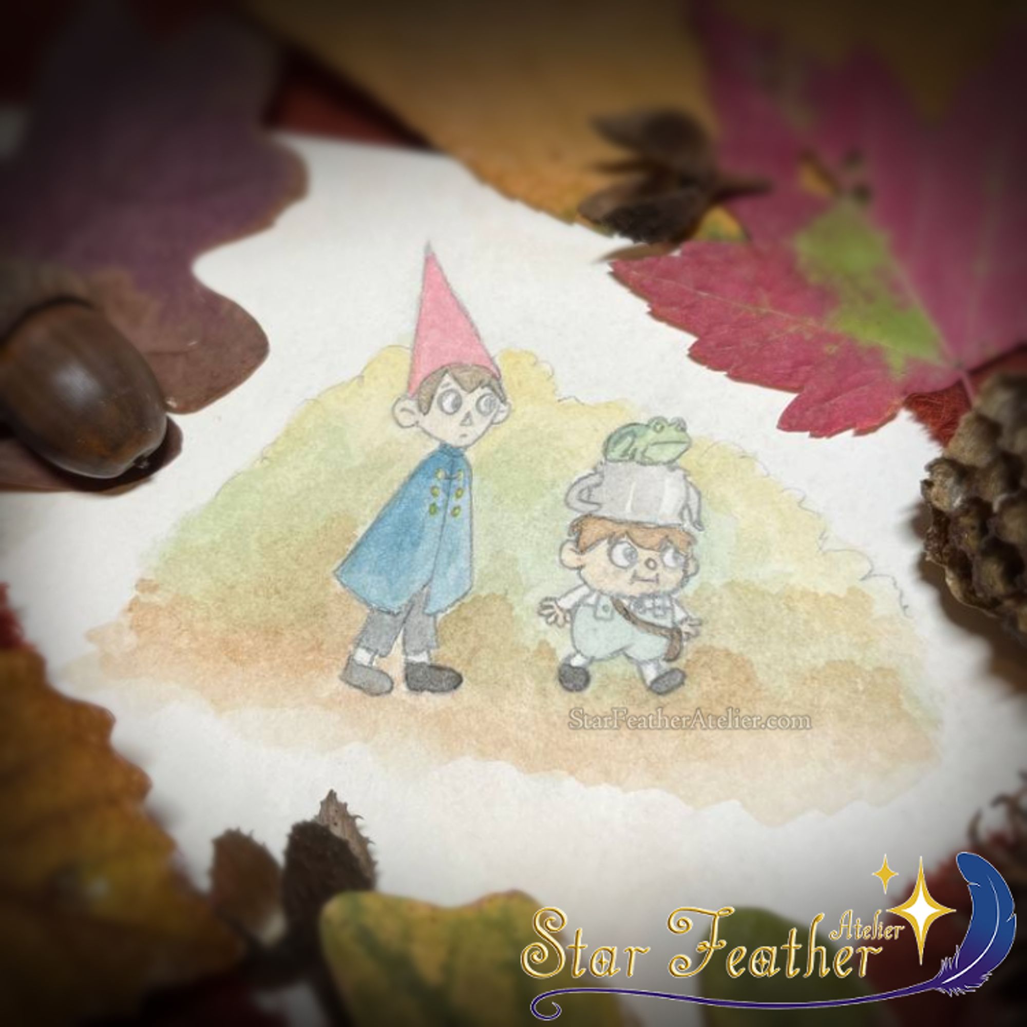 Photo of a small watercolor painting featuring Wirt and Greg from Over the Garden Wall. The two boys are walking amongst autumn colors, while Greg's frog rides on his teapot hat. The painting is surrounded by various autumnal foliage and decor.