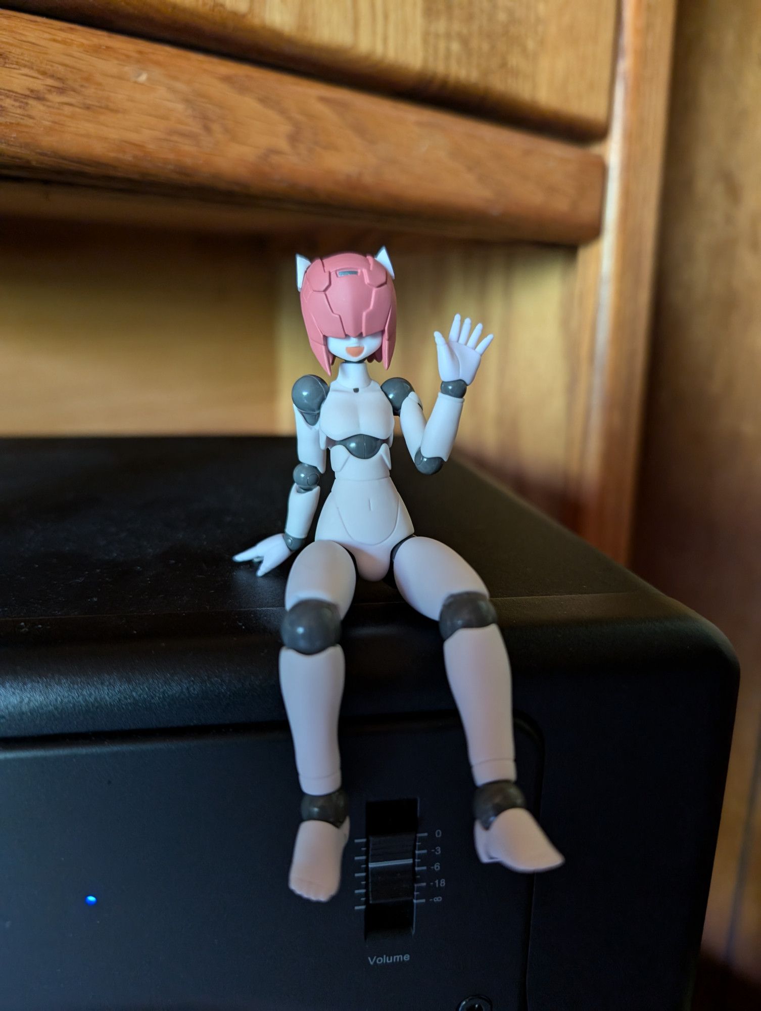 A photo of my Polynian Shamrock pose-able anime figure. He is sitting on top of my right studio monitor speaker.