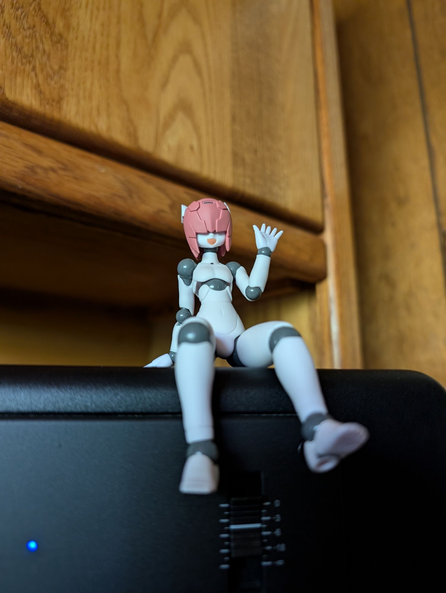 A photo of my Polynian Shamrock pose-able anime figure. He is sitting on top of my right studio monitor speaker.