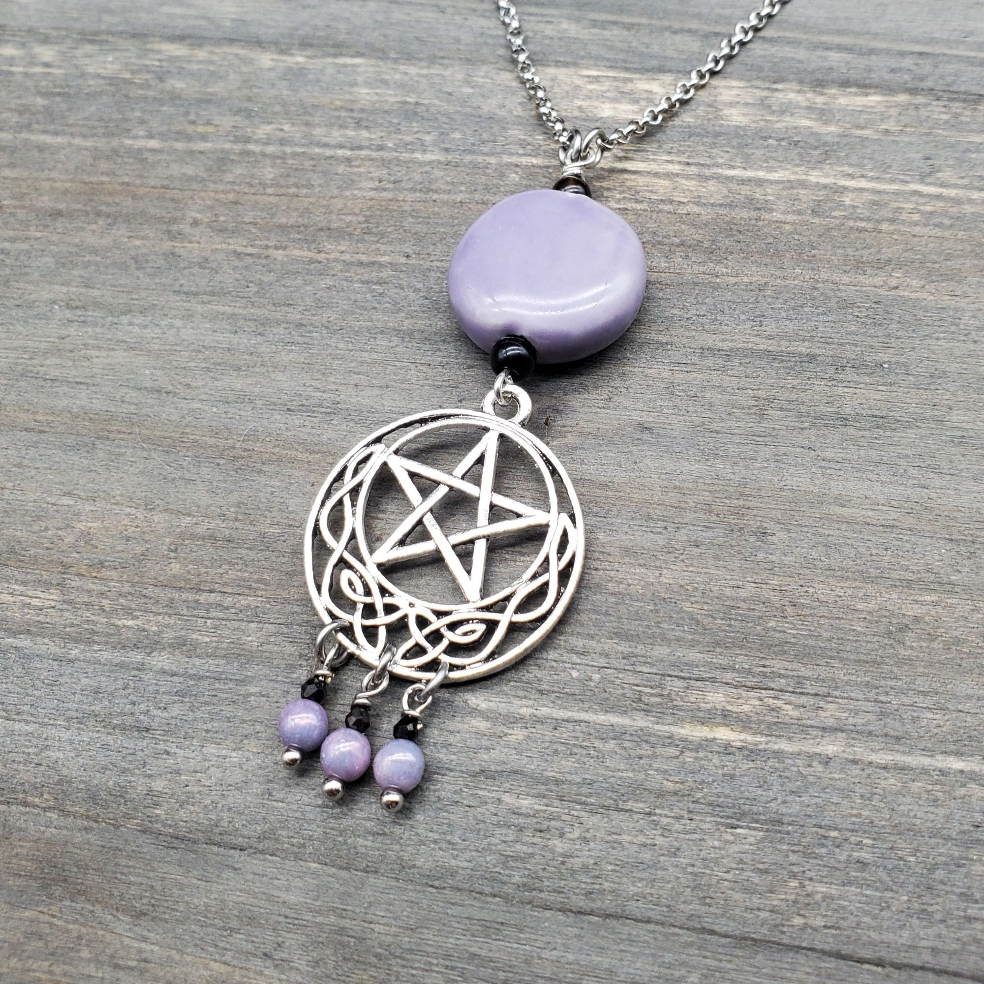 A pentagram necklace with lavender and black accents