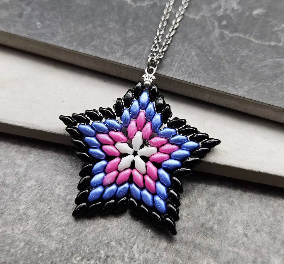 A black trans lives matter sewn star bead pendant with a silver chain 