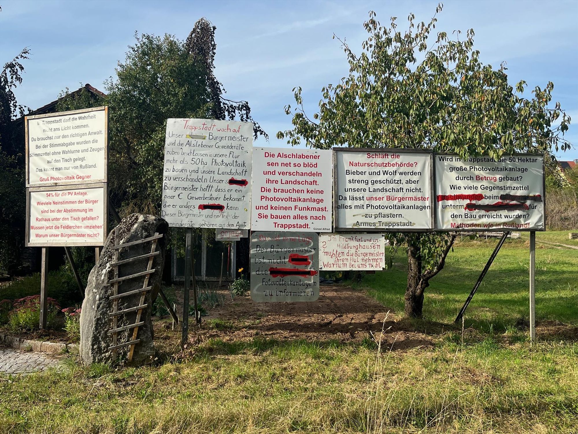 Protestschilder auf einem Privatgrundstück in Trappstadt (Bayern):

"In Trappstadt darf die Wahrheit nicht ans Licht kommen. Du brauchst nur den richtigen Anwalt. Bei der Stimmabgabe wurden die Stimmzettel ohne Wahlurne und Zeugen auf den Tisch gelegt. Das kennt man nur von Rußland. Gruß Photovoltaik Gegner"

"54% für die PV Anlage. Wieviele Neinstimmen der Bürger sind bei der Abstimmung im Rathaus unter den Tisch gefallen? Müssen jetzt die Feldlerchen umziehen Warum unser Bürgermäster nicht?"

"Trappstadt wach auf
Unser Bürgermeister und die Alslebener Gemeinderäte,
naben beschlossen in unsere Flur mehr als 50 ha Photovoltaik zu bauen ynd unsere Landschaft
zu verschandeln Unser s*****, Bürgermeister hofft dass er ein paar € Gewerbesteuer bekommt. die er anders *****,
kann
Dieser Bürgermeister und ein Teil der Gemeinderäte gehören aus dem Amt
gejagt"

"Schläft die Naturschutzbehörde? Bieber und Wolf werden streng geschützt, aber unsere Landschaft nicht.  (...)"

(kein Platz mehr)
