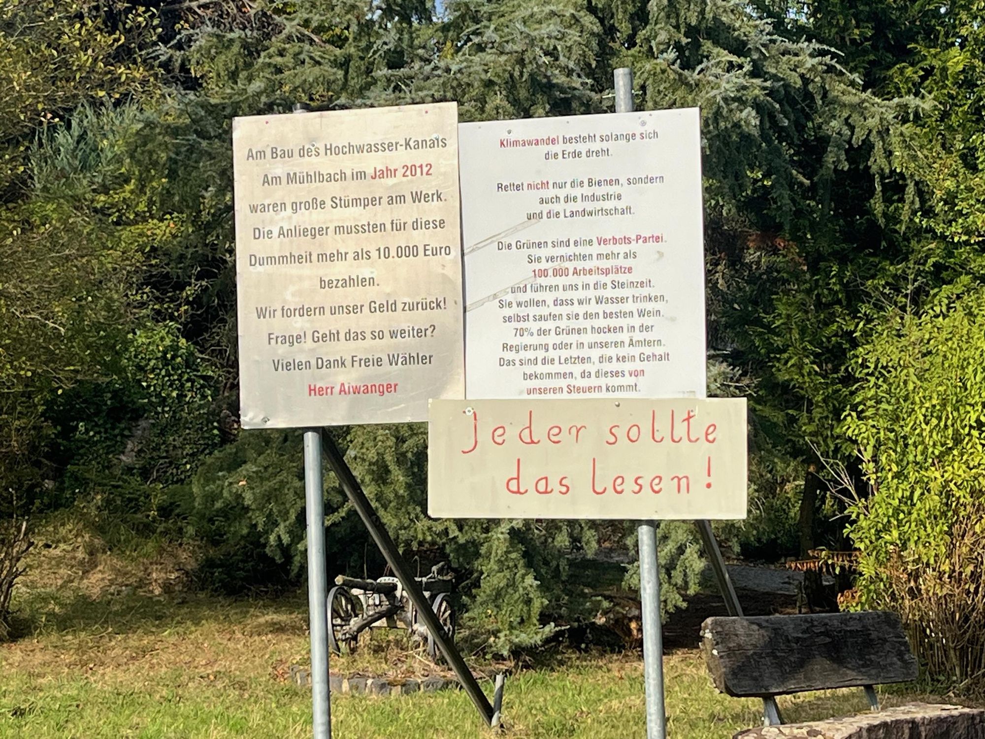 Protestschilder auf einem Privatgrundstück in Trappstadt (Bayern): 

"Am Bau des Hochwasser-Kanais Am Mühlbach im Jahr 2012 waren große Stümper am Werk. Die Anlieger mussten für diese Dummheit mehr als 10.000 Euro bezahlen. Wir fordern unser Geld zurück! Frage! Geht das so weiter? Vielen Dank Freie Wähler Herr Aiwanger"

"Klimawandel besteht solange sich die Erde dreht. Rettet nicht nur die Bienen, sondern auch die Industrie und die Landwirtschaft. Die Grünen sind eine Verbots-Partei. Sie vernichten mehr als 100.000 Arbeitsplätze und führen uns in die Steinzeit. Sie wollen, dass wir Wasser trinken, selbst saufen sie den besten Wein. 70% der Grünen hocken in der Regierung oder in unseren Ämtern. Das sind die Letzten, die kein Gehalt bekommen, da dieses von unseren Steuern kommt."

und

"Jeder sollte das Lesen!"