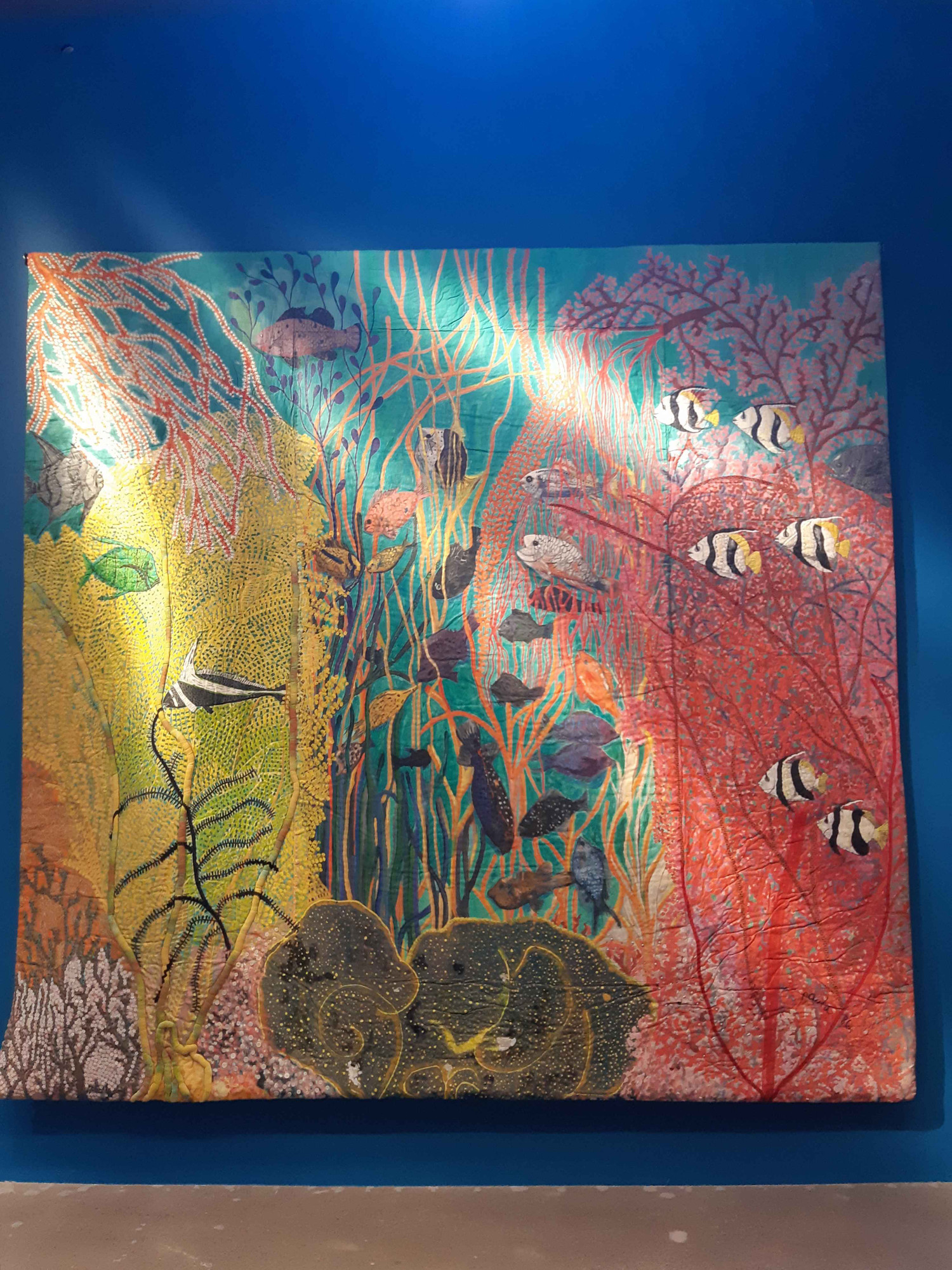 Hanging trapunto (like a giant quilted painting) by Pacita Abad, depicting an underwater scene.