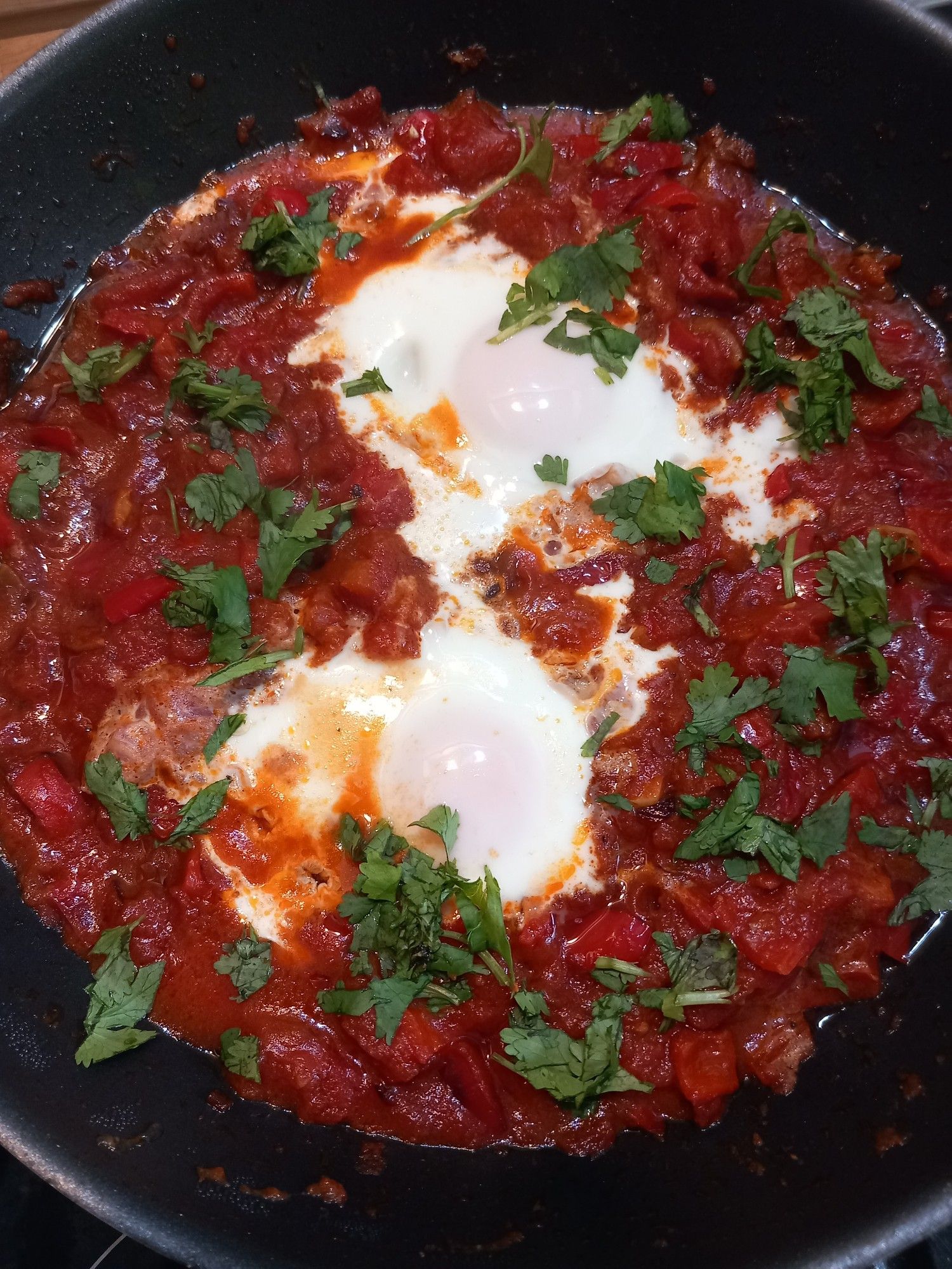 Shakshuka mit zwei Eiern in einer Pfanne.