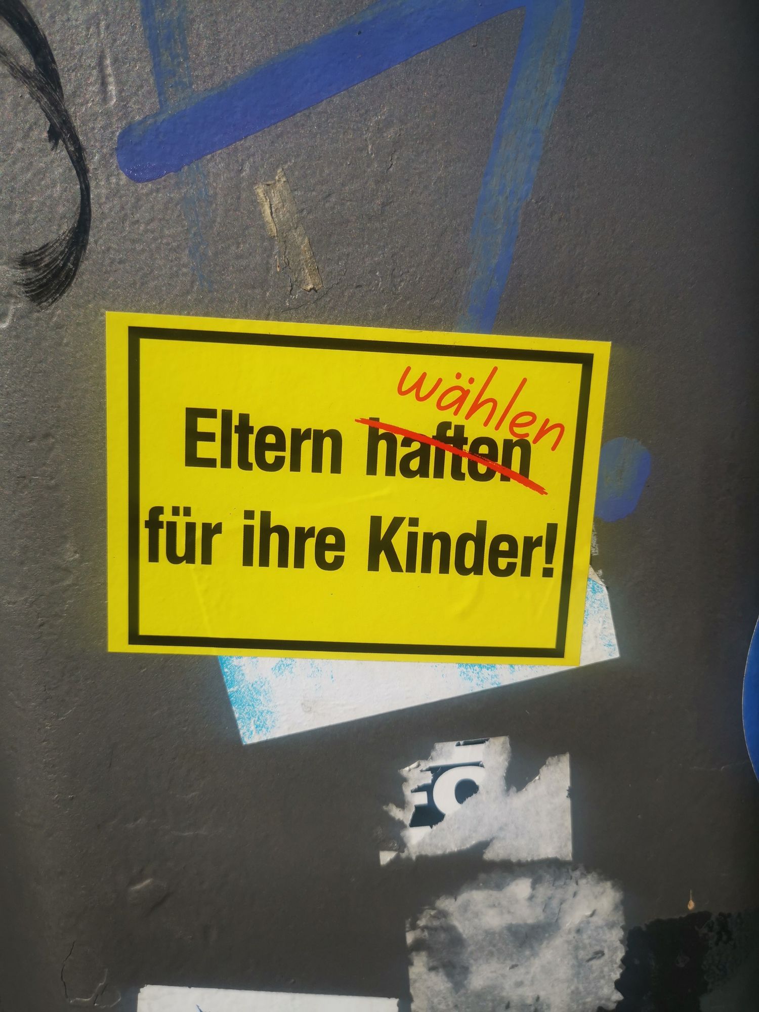 Sticker der das Schild "Eltern haften für ihre Kinder" nachahmt. Das "haften" ist rot durchgestrichen darüber steht rot "wählen", so dass "Eltern wählen für ihre Kinder" herauskommt. 