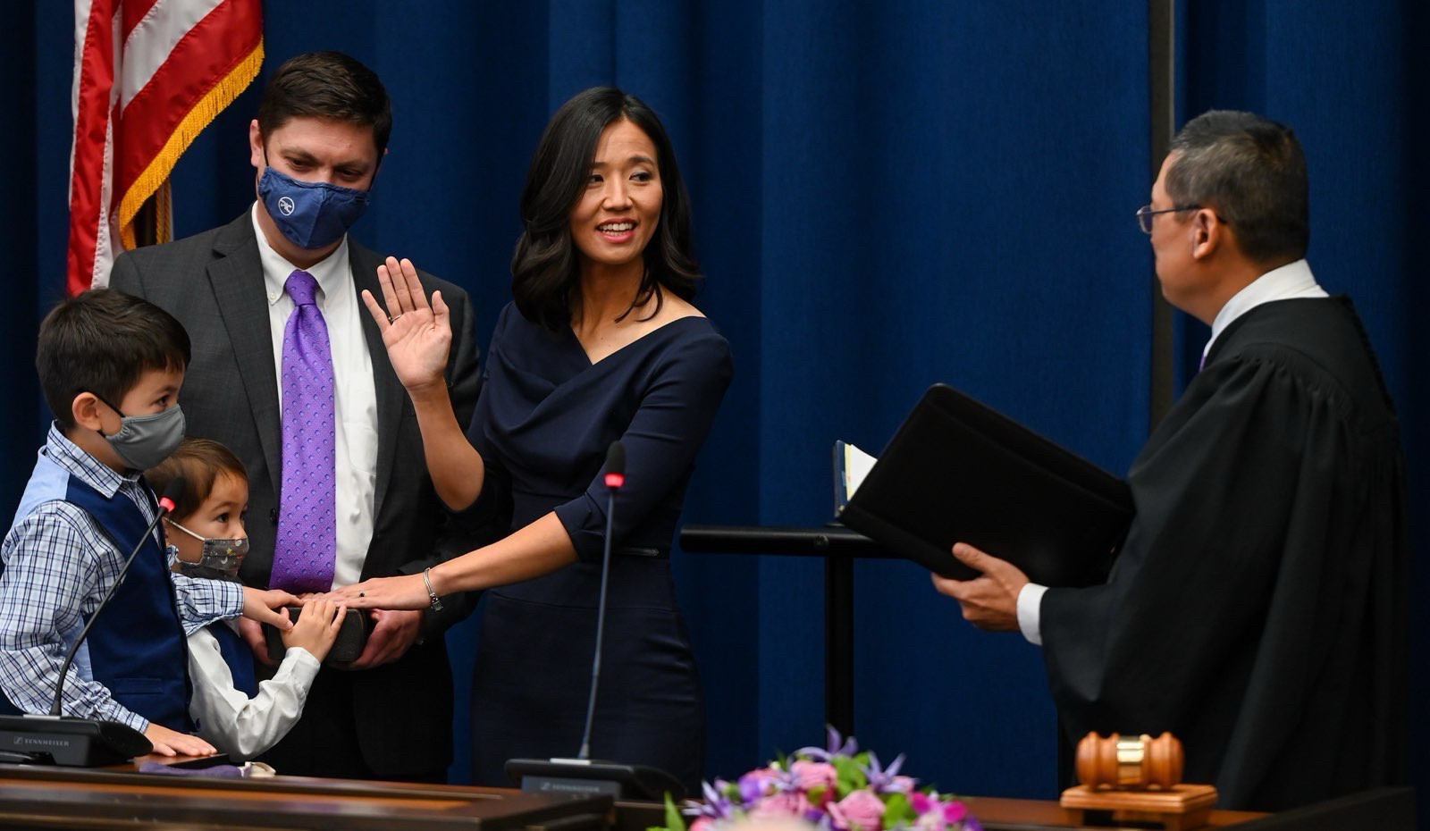 An image from Mayor Wu’s swearing in ceremony on November 16, 2021 in Boston City Hall. Michelle raises her right hand as Judge Myong Joun administers the oath of office; her left hand is on the Aitken Bible held by her husband and two sons.