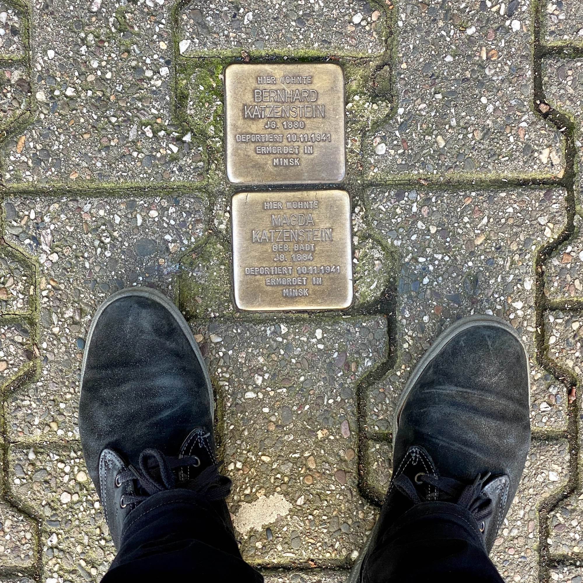 Zwei Stolpersteine, darunter die Füße des Fotografen.

HIER WOHNTE BERNHARD
KATZENSTEIN
JG. 1880
DEPORTIERT 10.11.1941
ERMORDET IN MINSK

HIER WOHNTE MAGDA
KATZENSTEIN
GEB. BADT
JG. 1884
DEPORTIERT 10.11.1941
ERMORDET IN MINSK