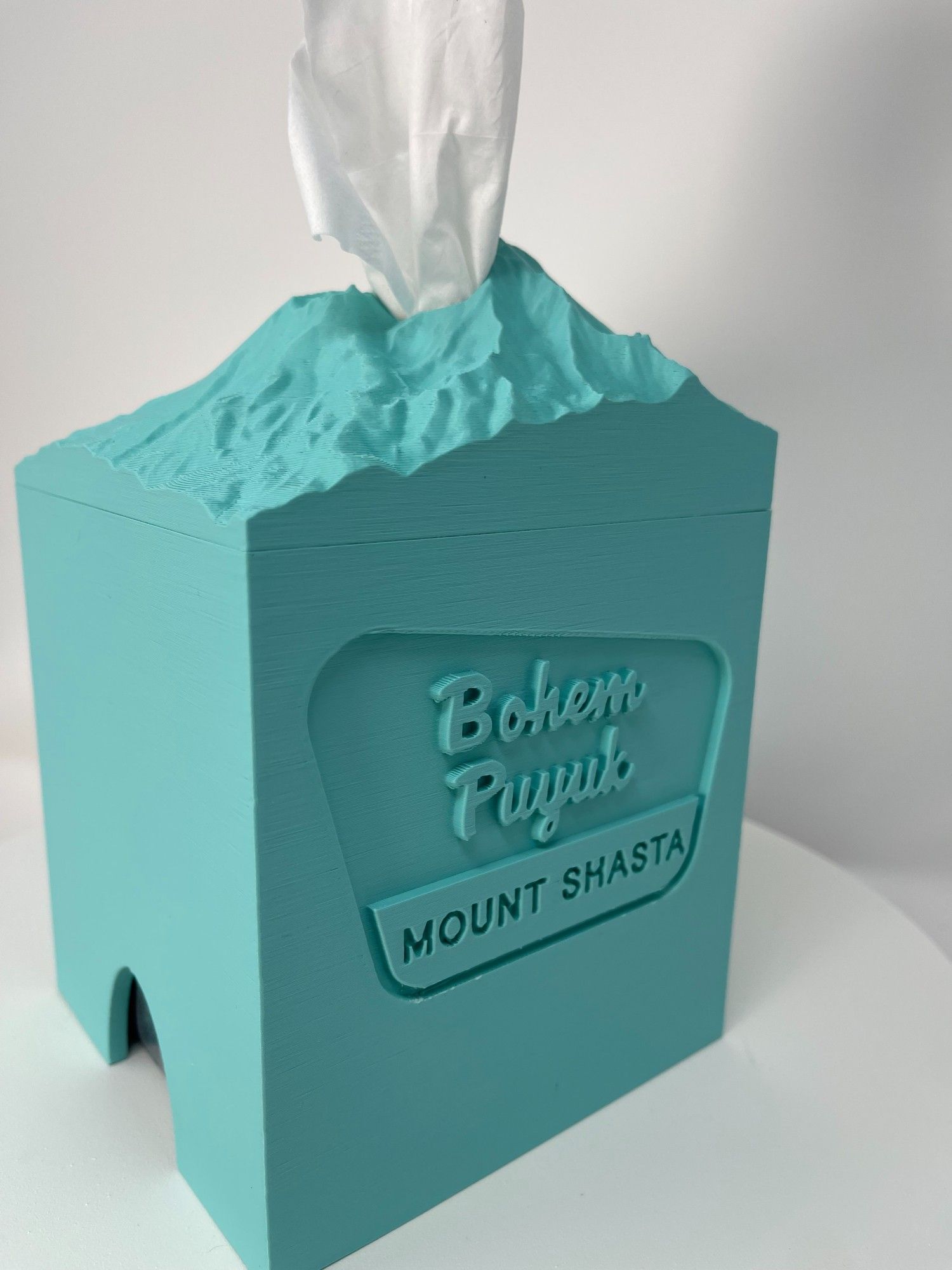 Cubic tissue box cover in the shape of Mt Shasta in seafoam color.