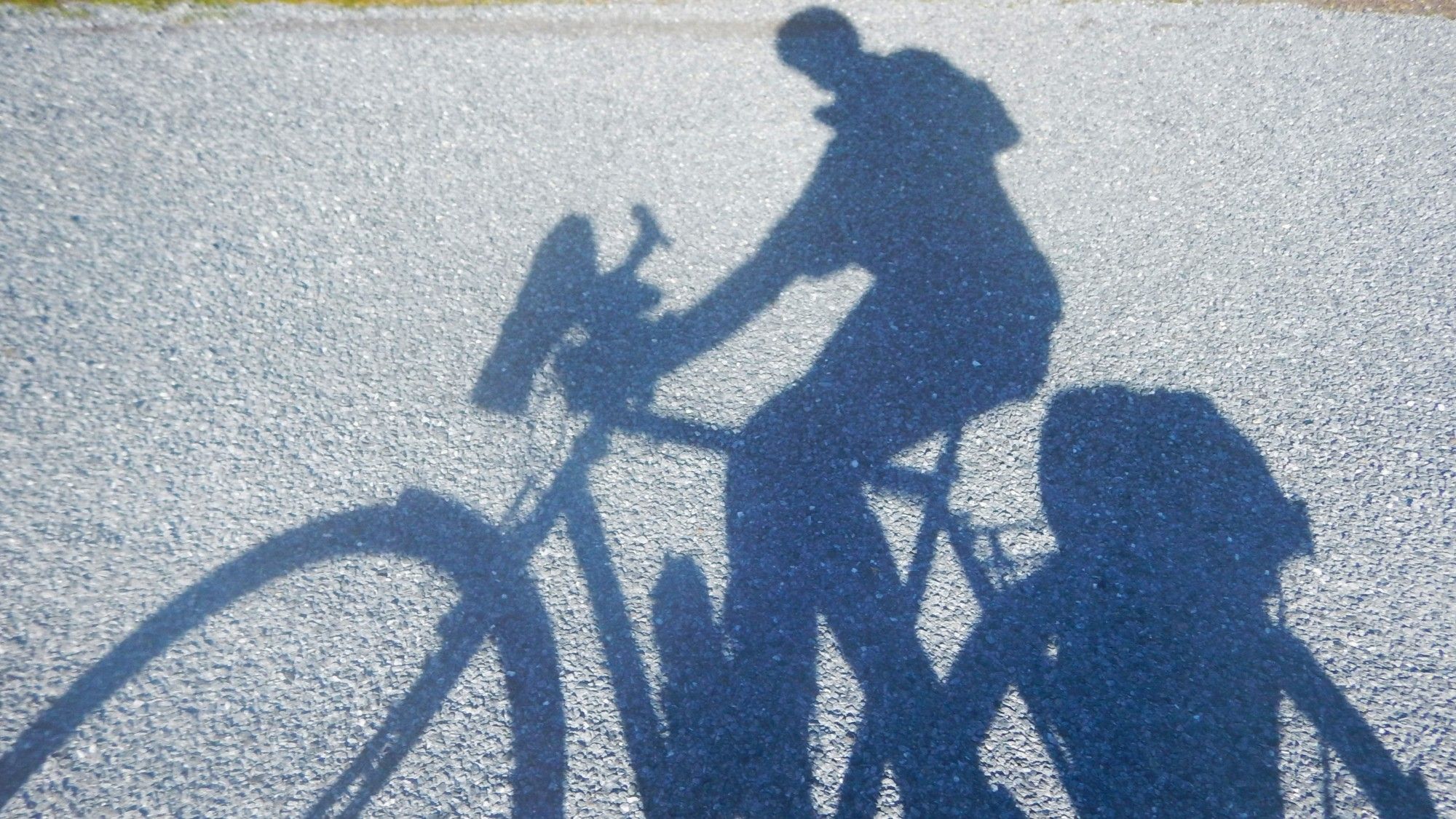 Shadow of a cyclist on the road in todays sunshine