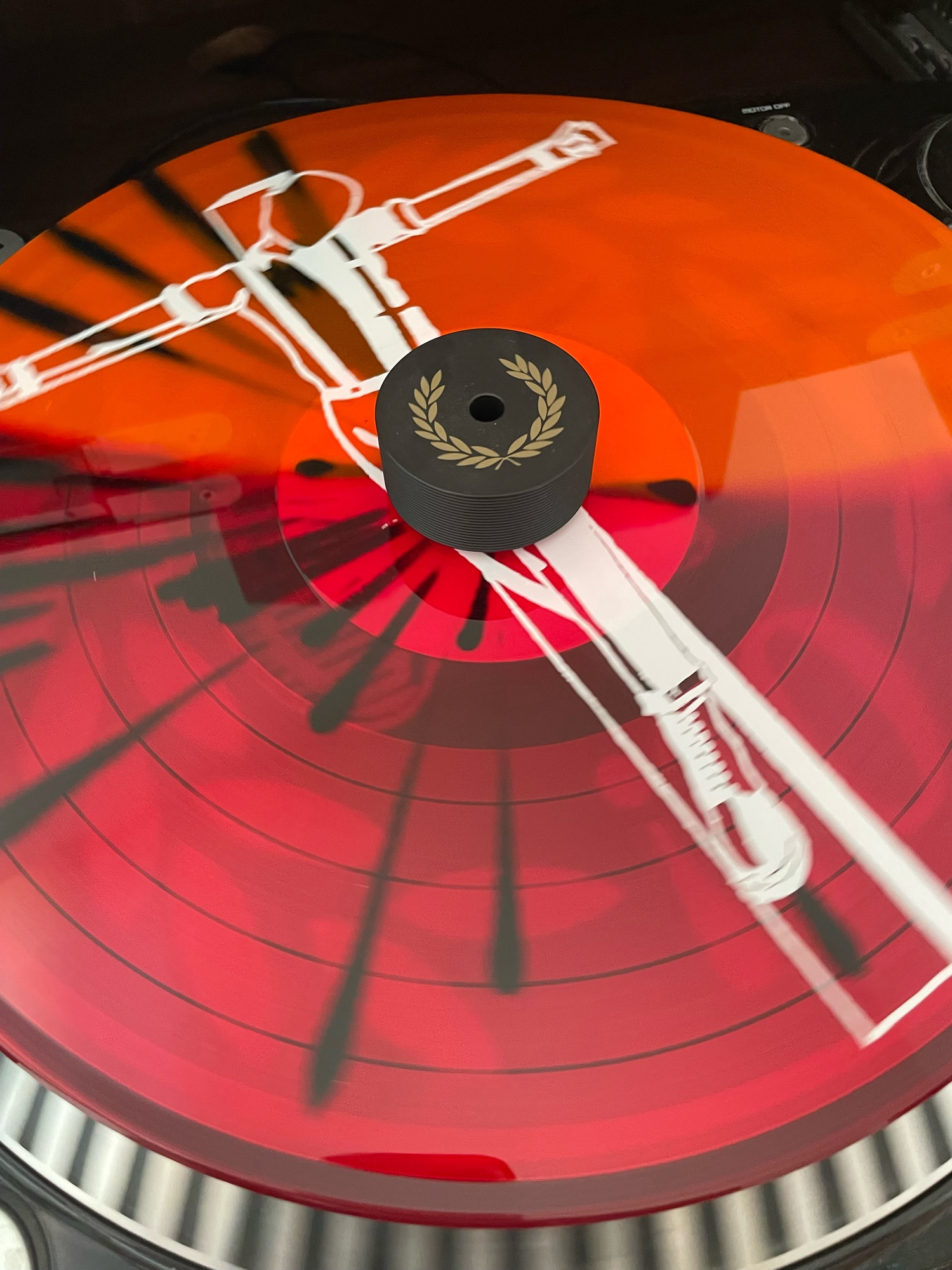 splattervinyl in rot-orange mit schwarzen Sprenkeln. Aufdruck eines Crucified Skin