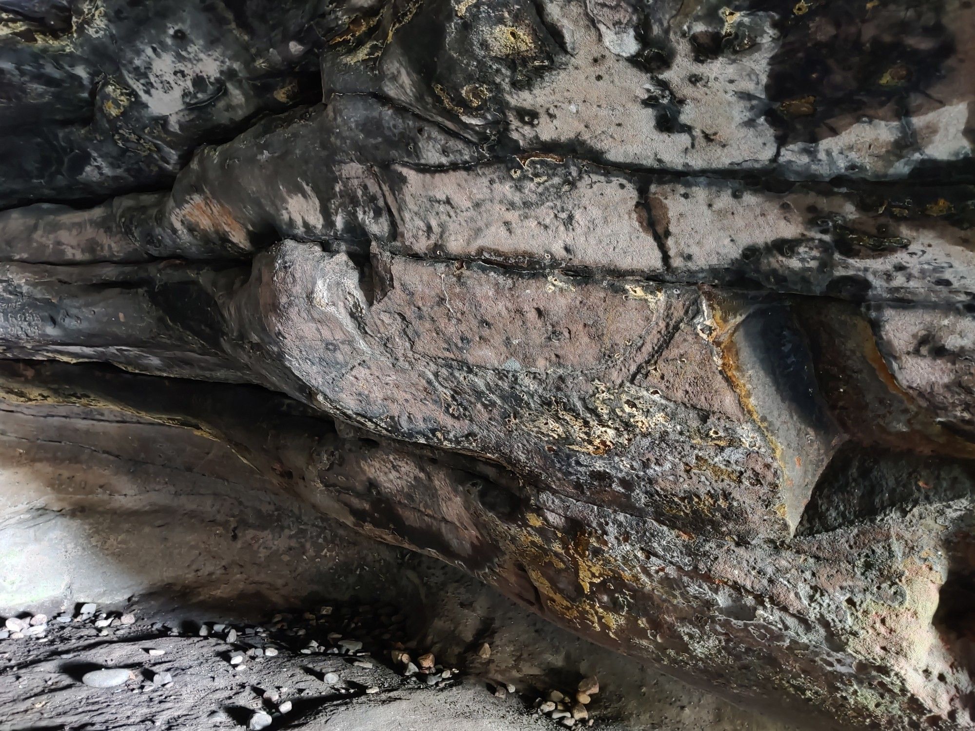 Cave wall with lichen and a difficult to see carving