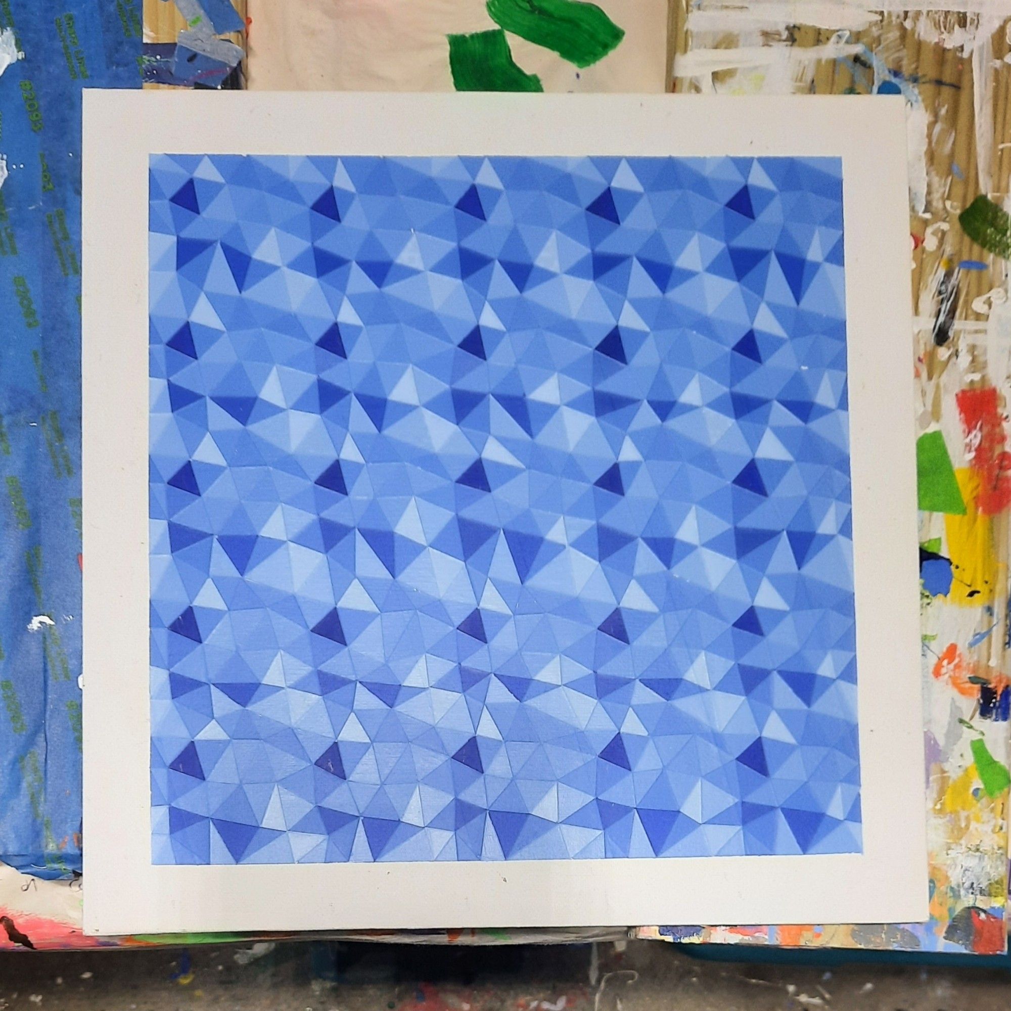 An abstract painting consisting of a series of adjacent blue triangles. It is a square painting with a white boarder