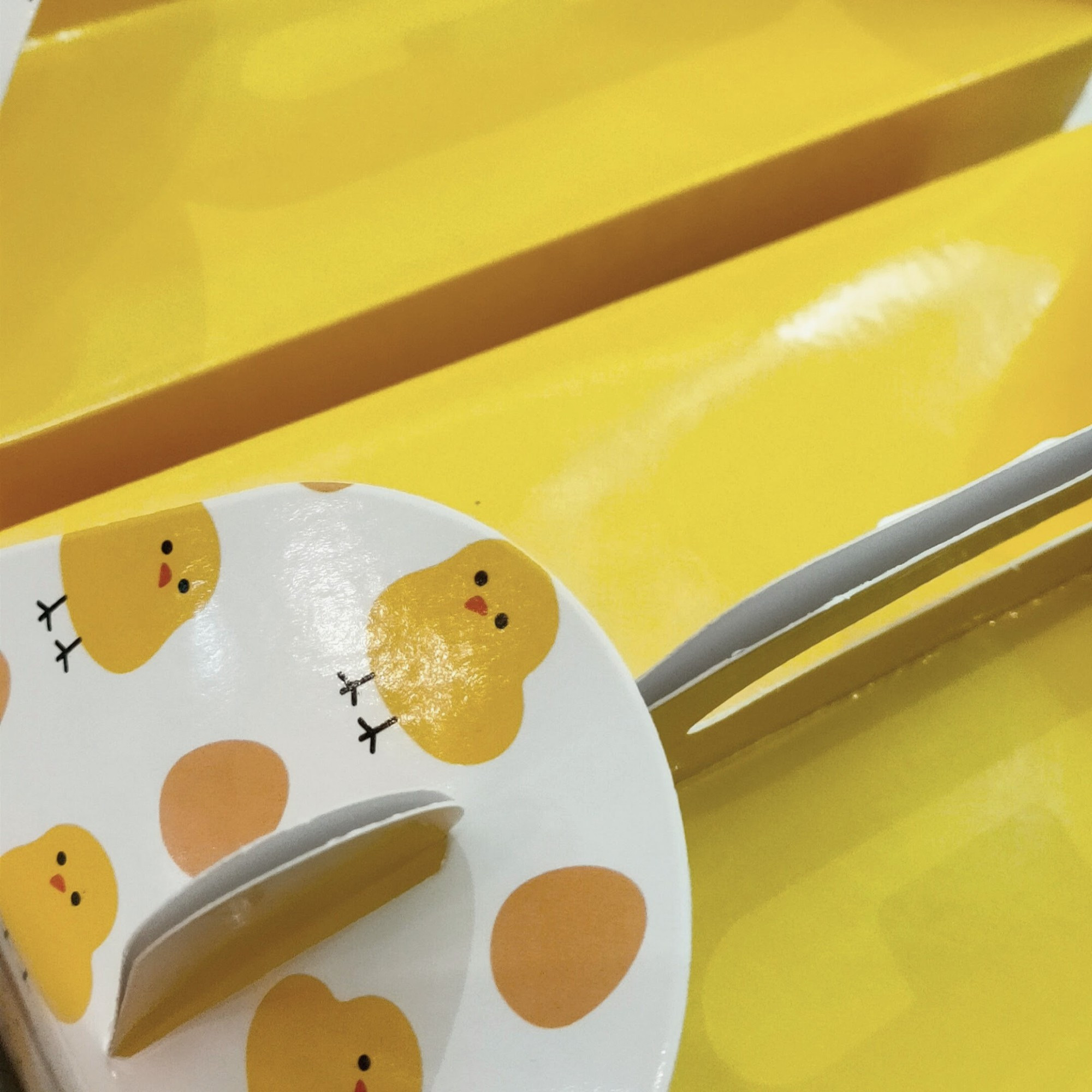 yellow takeout box with prints of chicks and eggs