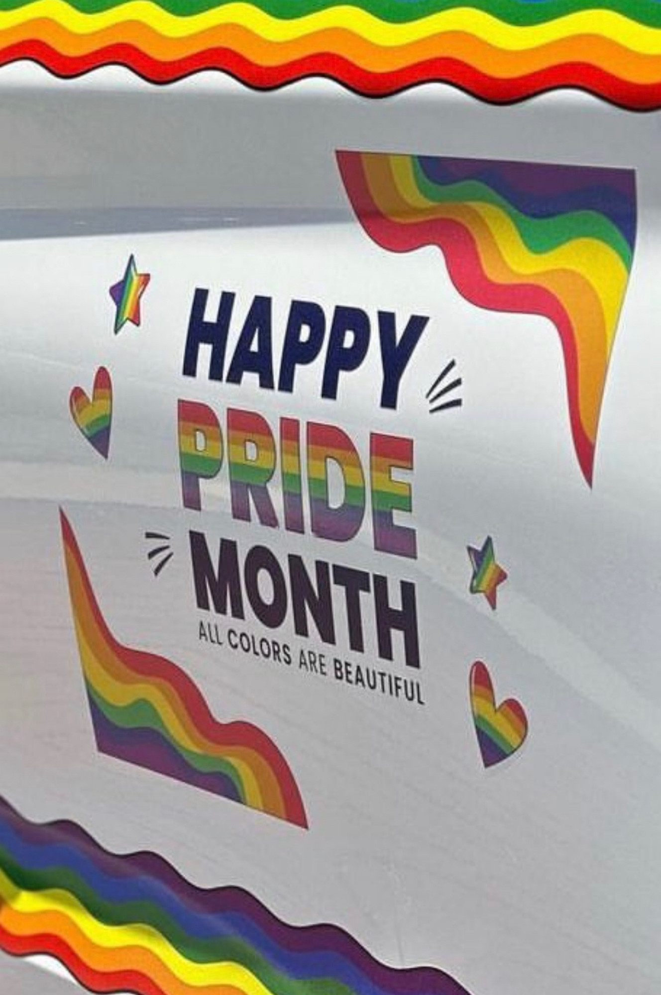 a closeup of the side of an NYPD patrol vehicle with a rainbow decal and the text saying HAPPY PRIDE MONTH - ALL COLORS ARE BEAUTIFUL