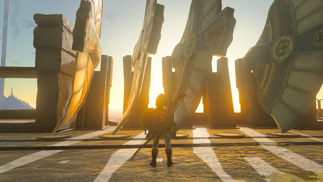 Link stands before a series of gliders mounted one racks on their side, on a sky island. The sunset light shines through the openings between gliders, casting long shadows