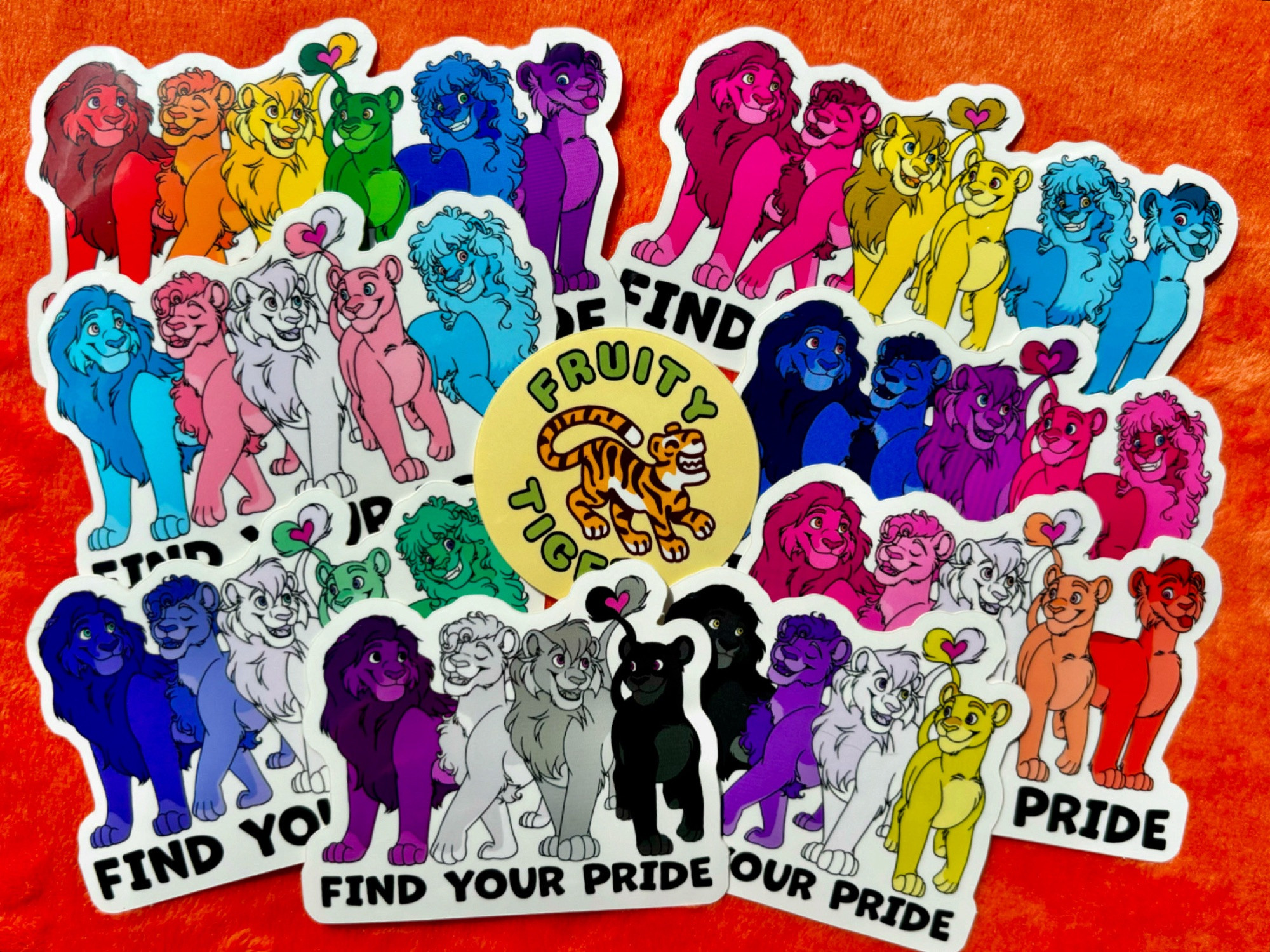 Rainbow lion pride flag stickers with pride, pan, trans, bi, gay, lesbian, ace, and non-binary coloring. Lions are in the style of the lion king. Each lion is colored for a different band on the pride flag. Two of the lions tails form a heart.