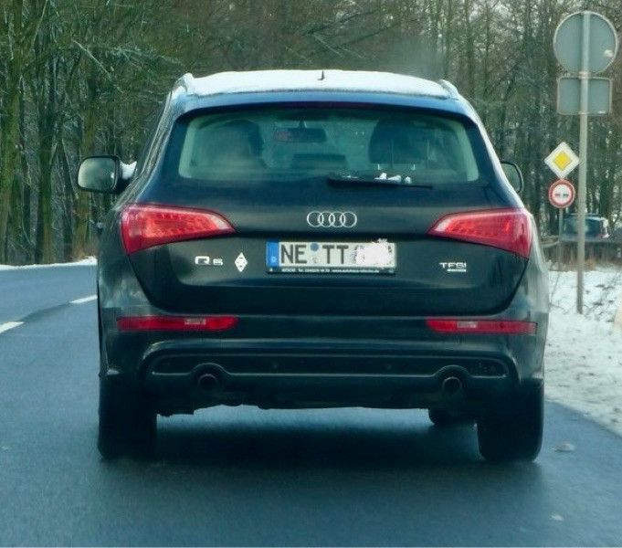 Heck eines schwarzen Autos mit dem Kennzeichen NE  TT. Die Zahlen sind unkenntlich gemacht. 