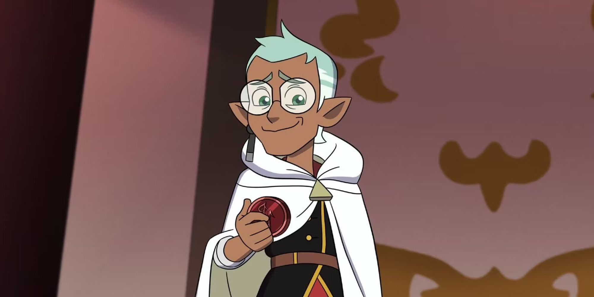 A still from the animated show THE OWL HOUSE featuring Raine Whispers, a nonbinary character with brown skin, elf ears, and friendly round glasses.