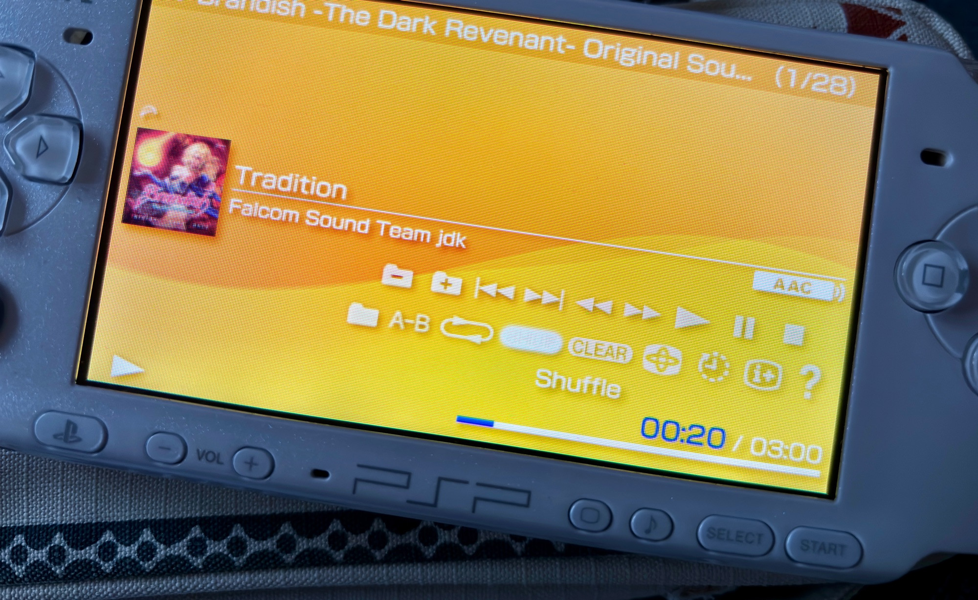 A photo of a PSP, playing the track “Tradition” from the Brandish The Dark Revenant soundtrack like it’s 2009