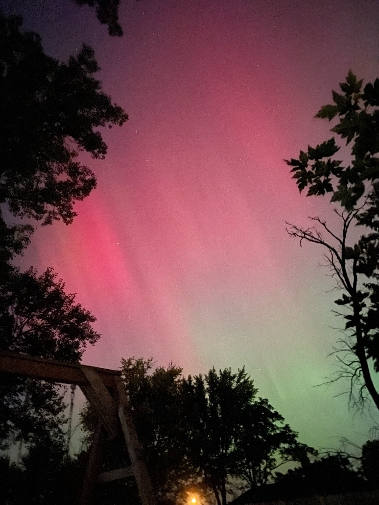 Green and red aurora borealis streaks the night sky