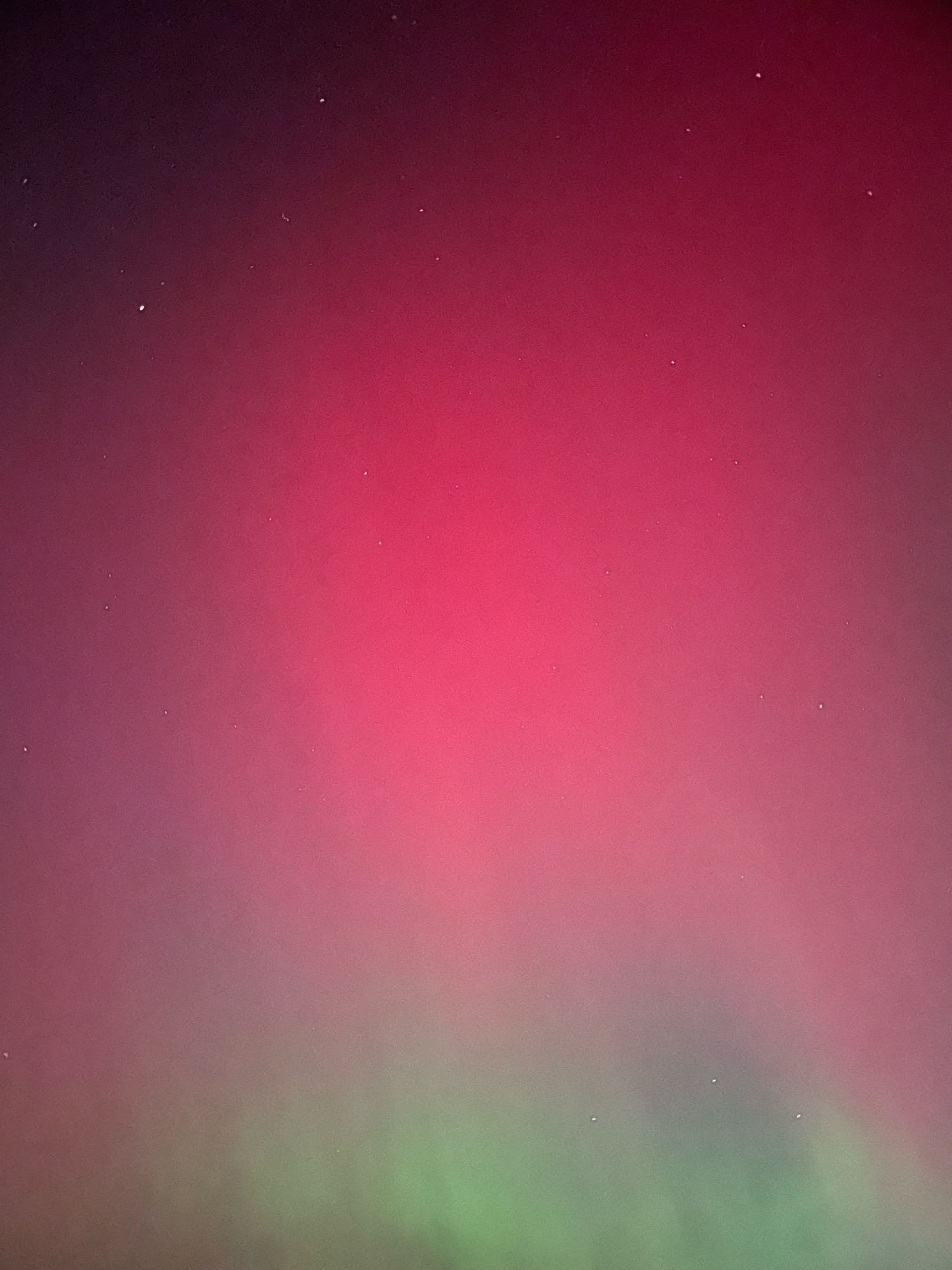 Green and red aurora borealis streaks the night sky