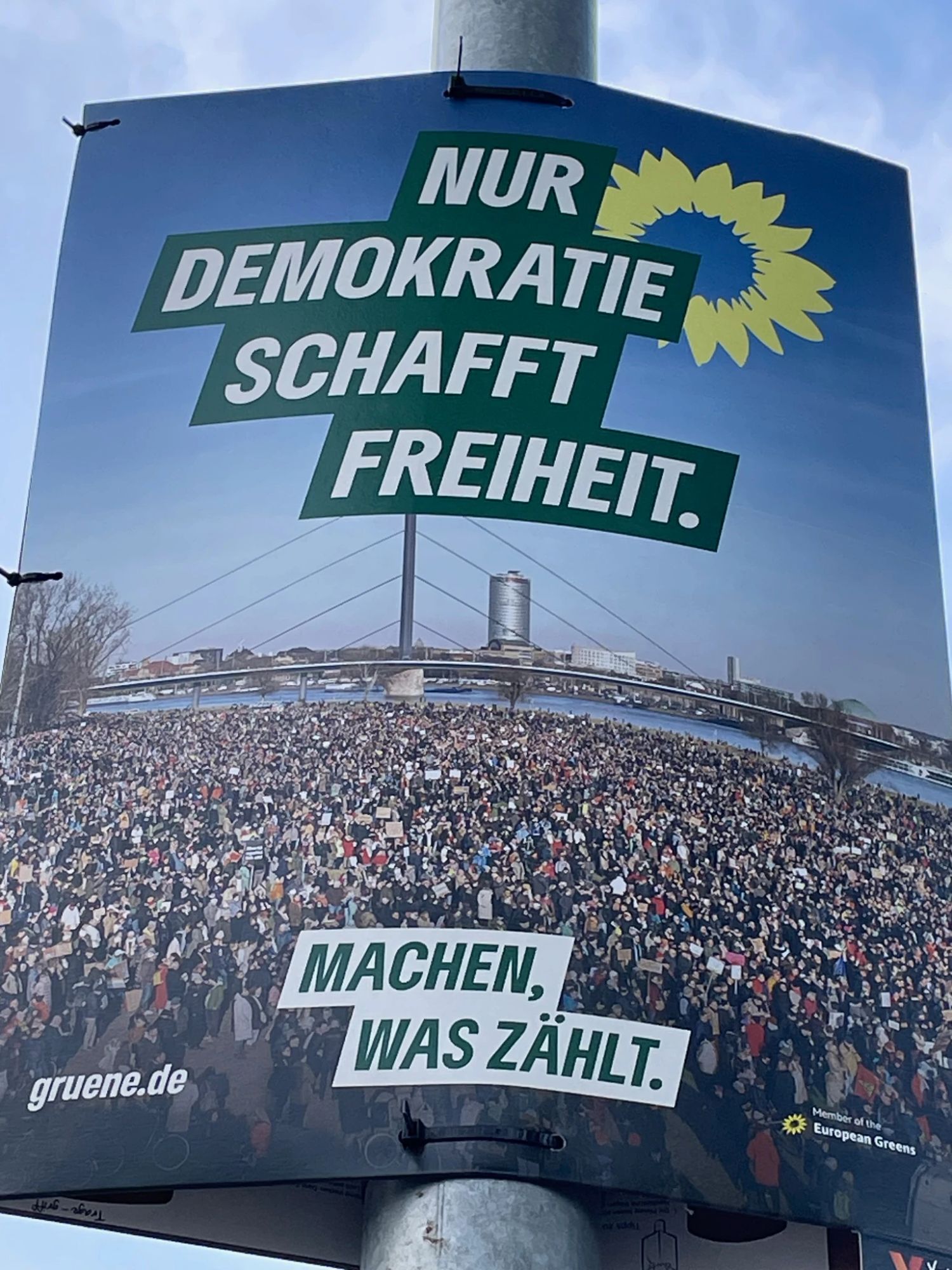 Wahlplakat der Grünen aus dem Europawahlkampf. Überschrift: "Nur Demokratie schafft Freiheit". Darunter ein Foto der großen Demo gegen rechts in Düsseldorf vom Anfang des Jahres