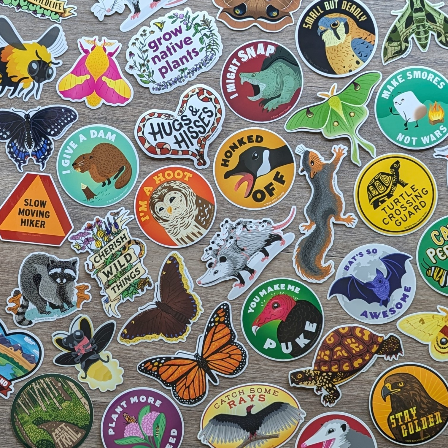 A flat lay of dozens of brightly colored stickers featuring illustrations of animals and plants