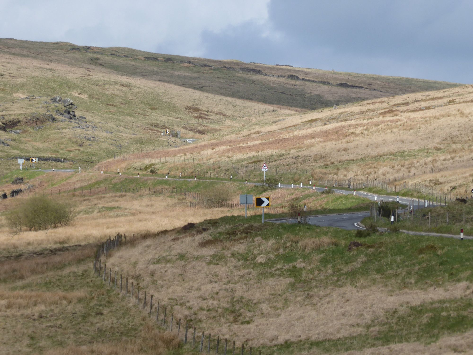 The s-bends of a main road curve through the moorland hills climbing into the distance.