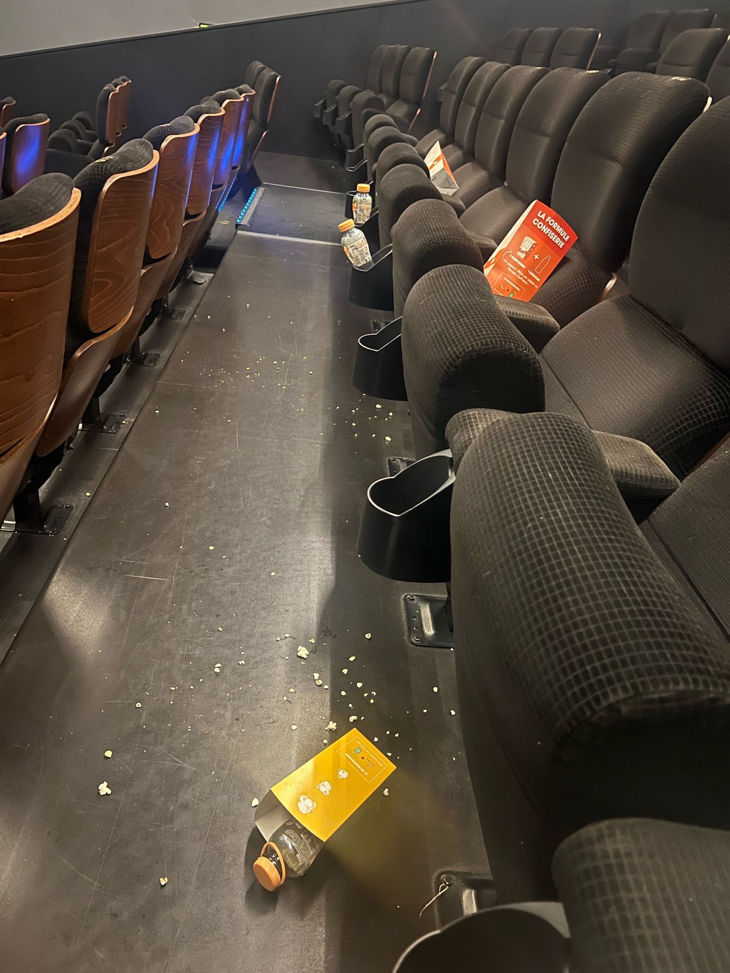 Boîtes de popcorn et bouteilles vides laissées dans une salle de cinéma