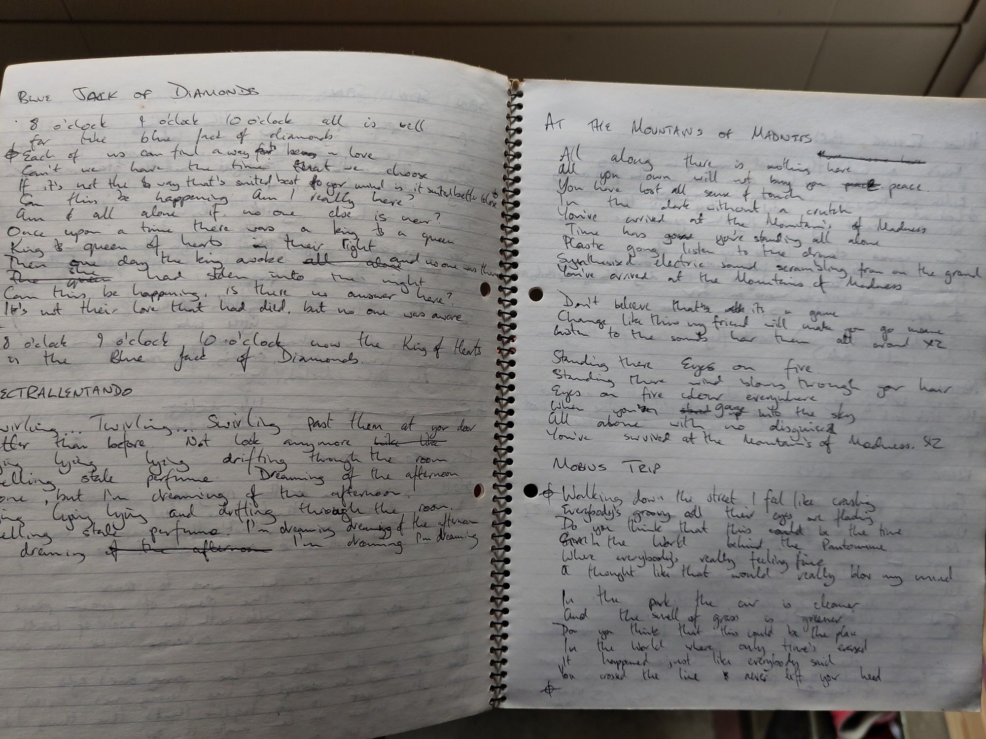 An open ring bound notebook with the lyrics for Blue Jack of Diamonds, Electrallentendo, At the Mountains of Madness and Mobius Trip written in ballpoint pen. Written down maybe 30 years ago?