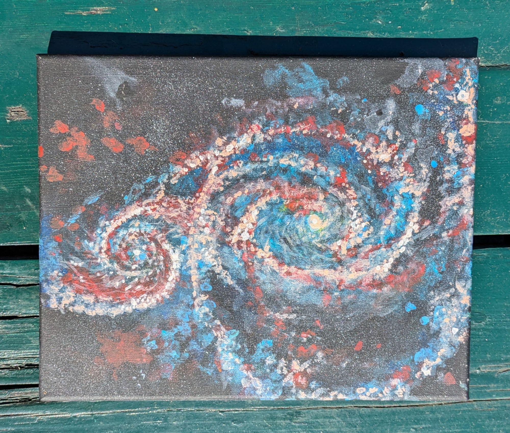 Photo of a painting showing two spiral galaxies merging