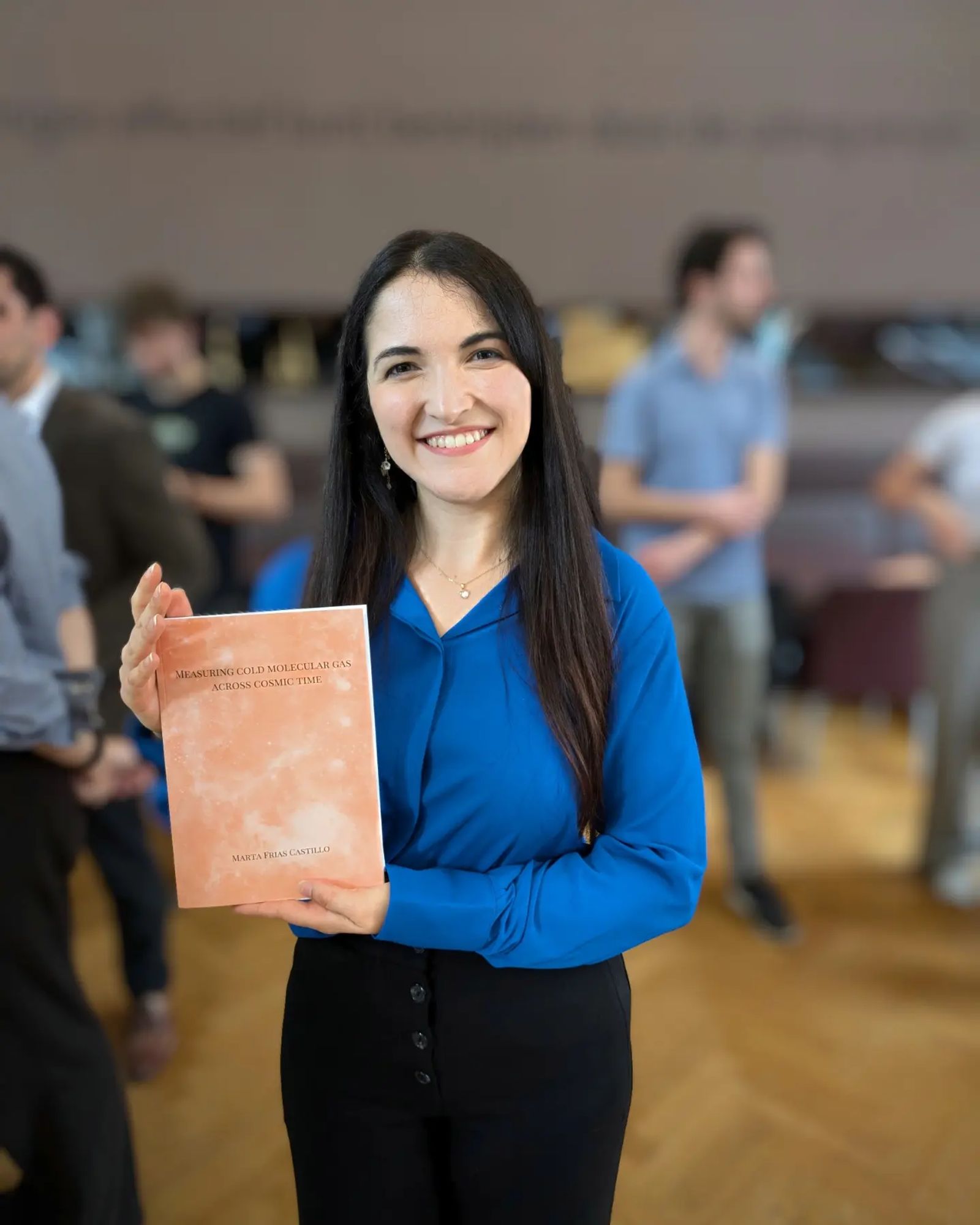 Photo of Marta holding her thesis 