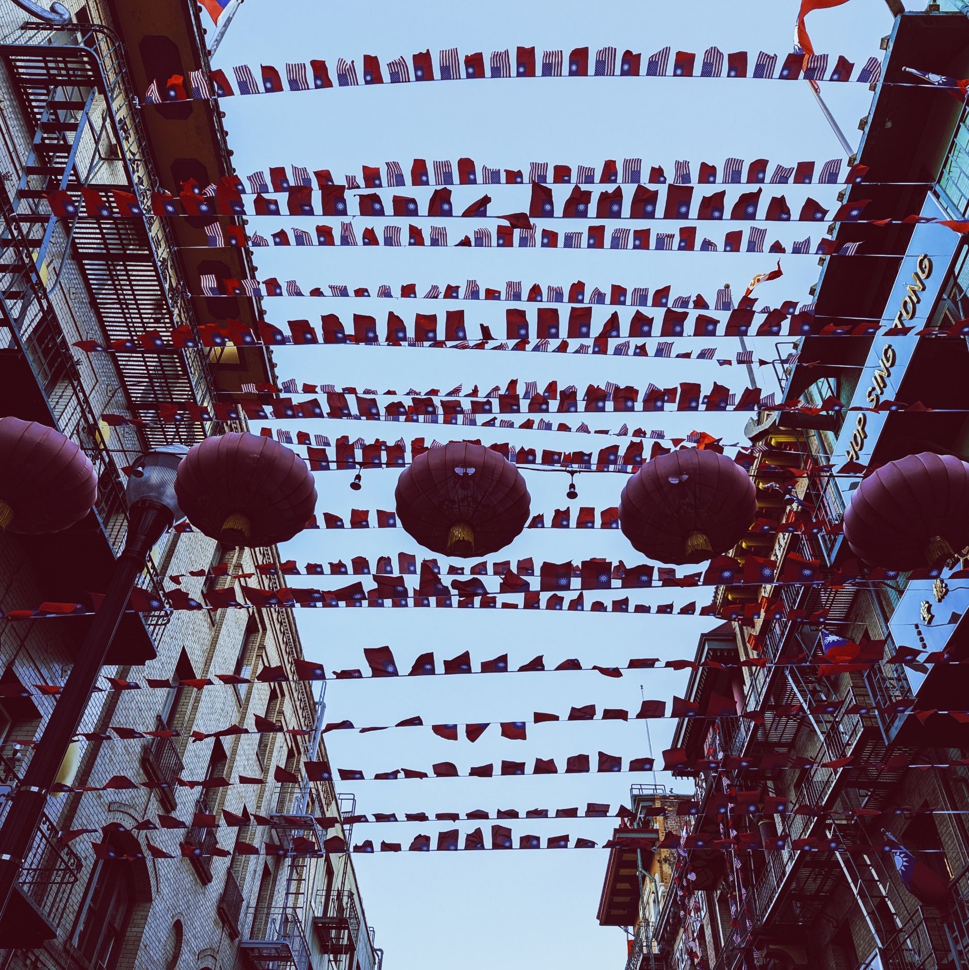 Numerous lanterns and flags are strung across Waverly between the Hop Sing Tong and Gee Tuck / Sam Tuck Association. The effect, against the narrow sky left between the relatively tall buildings lining the narrow street, is dazzling.