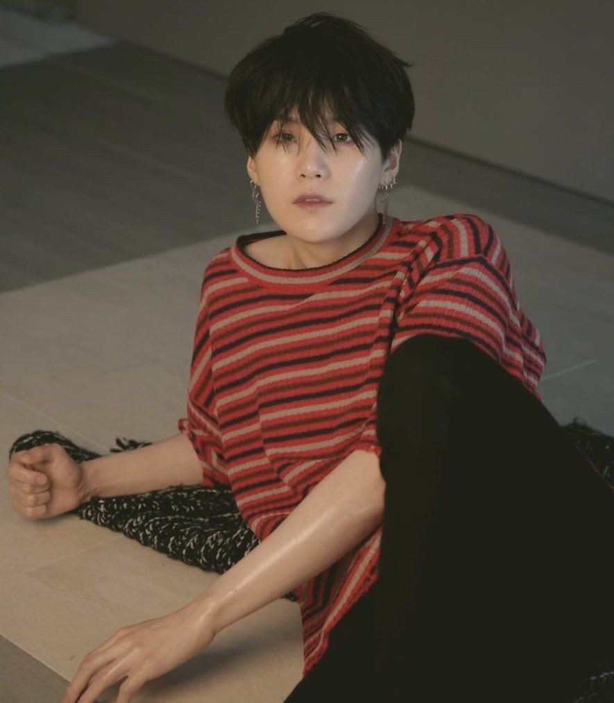 Yoongi on the floor, leaning on one arm.