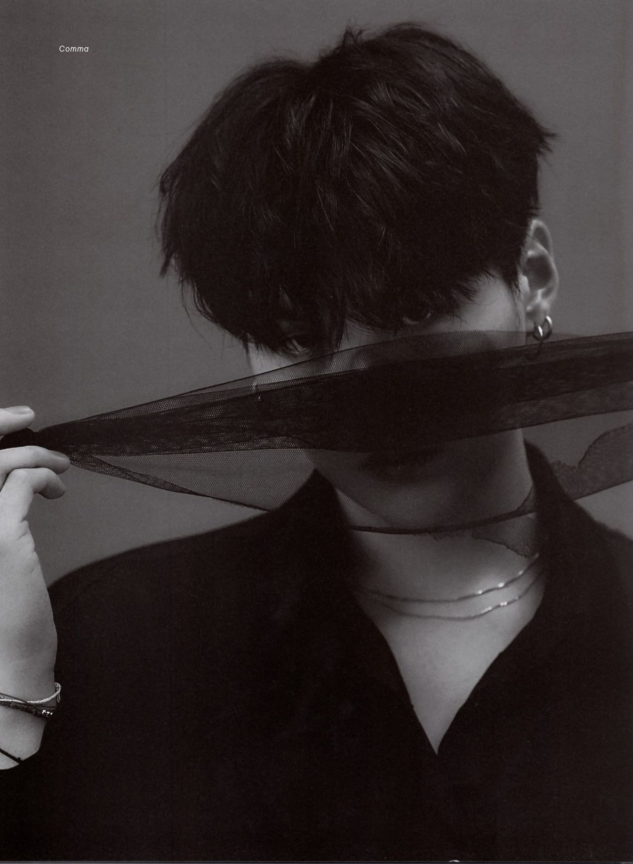 Black and white photo. Yoongi is all in black with a thin black scarf over his face