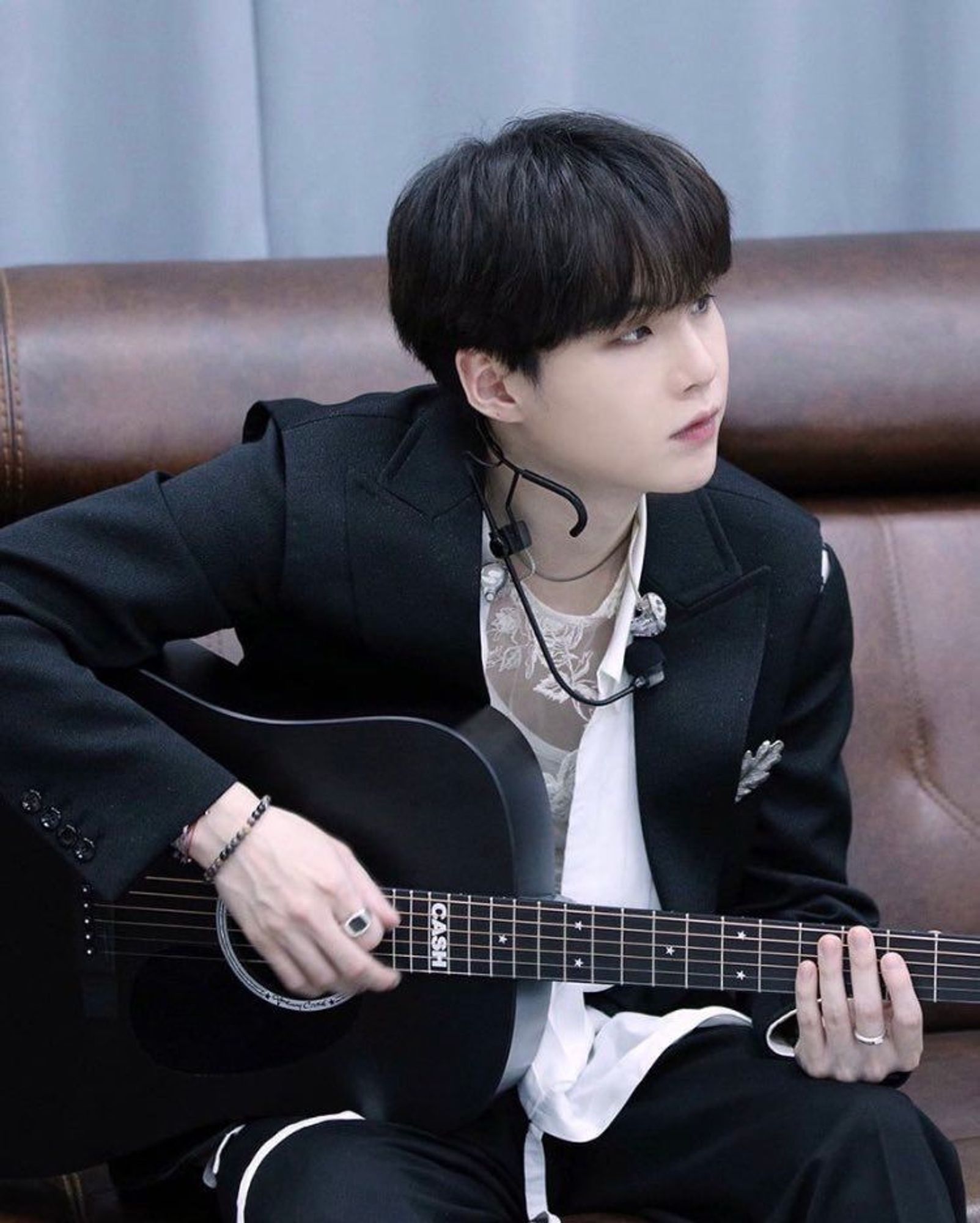 Yoongi playing a guitar