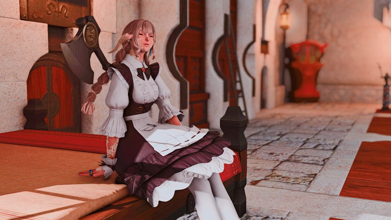 A Raen Au Ra wearing her maid uniform is sitting on their bed in a warmly lit inn room with white walls and floors. She has a content look on her face as the sunlight enters through the bedside window. 