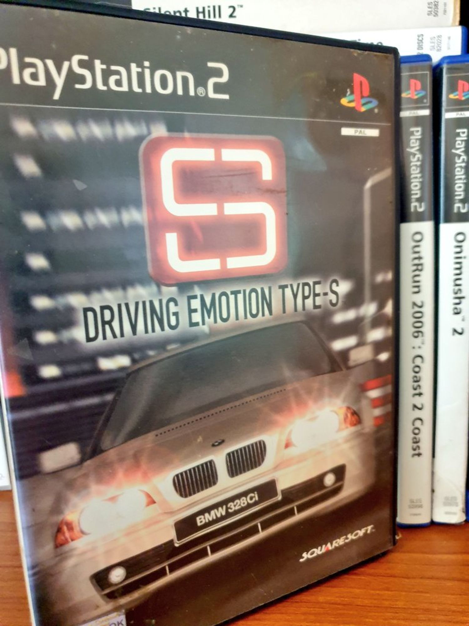 The front cover of the PAL release of Driving Emotion Type-S, showing a BMW 328Ci from the front against a night city street, headlights blazing