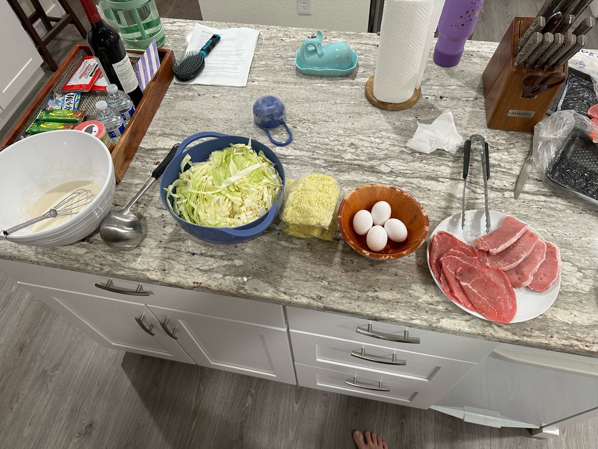 Kitchen island with multiple plates and bowls of ingredients prepped to be cooked