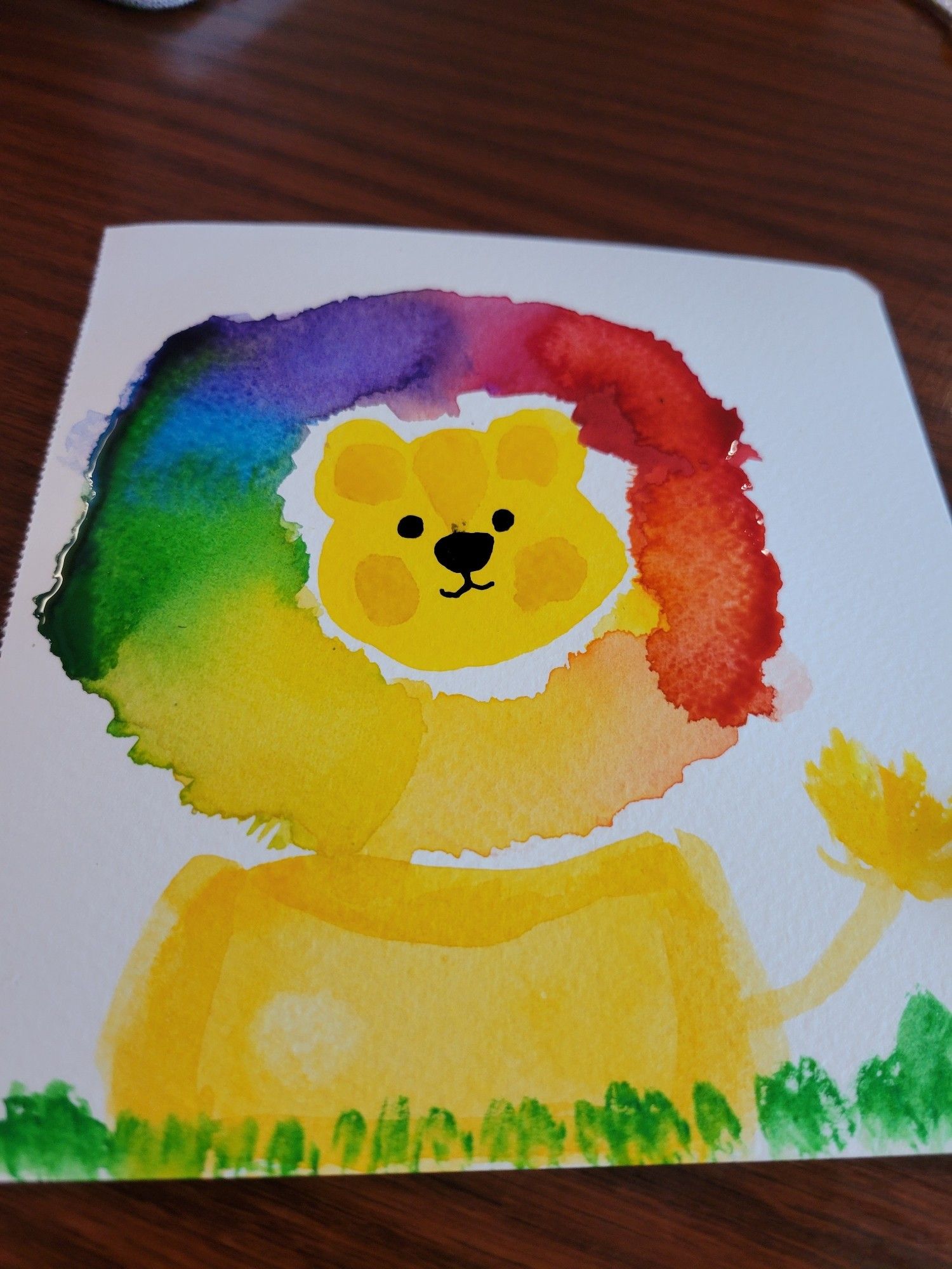 A watercolor lion with a rainbow mane in the style of a 3yo who doesn't know how paintbrushes work because Liana failed art class in 2nd grade and never recovered.