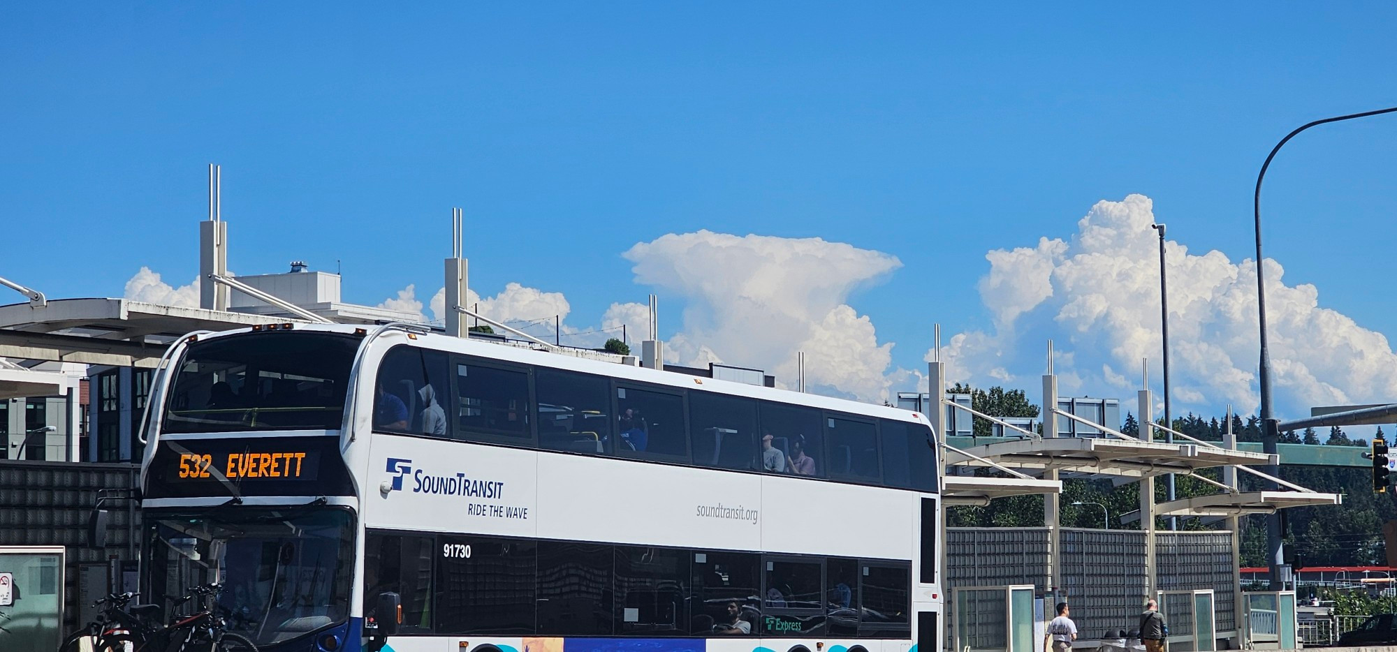 Sound transit Route 532 bus going to Everett at the Totem late freeway station. There are pretty looking clouds on the horizon 