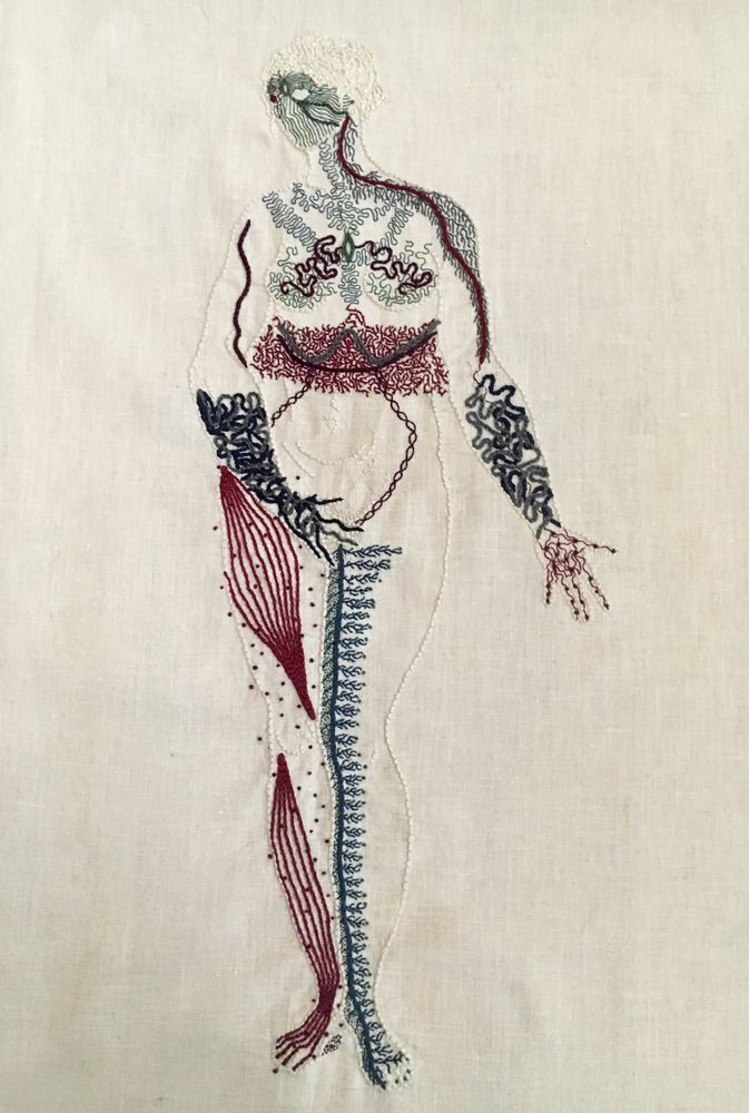 Body Map (2016)

An outline of a naked woman is embroidered on linen in the same bone white colour as the linen. She stands legs together, her right hand covering her groin, her left hand, palm up, extended slightly to her side. She looks to the right. Her entire body except for her belly is covered in intricate markings representing different neurological sensations. Her face is a mask of green lines, feathery grey lines cover her shoulders and chest. There is a thick band of intricate burgundy stitching around her waist. Her forearms and hands are covered in thick blue undulant lines. Her right leg has bands of burgundy along the muscles, with small dots around them. Her inner left leg has a thick line of blue running up it, with thin branches spreading towards her outer leg.