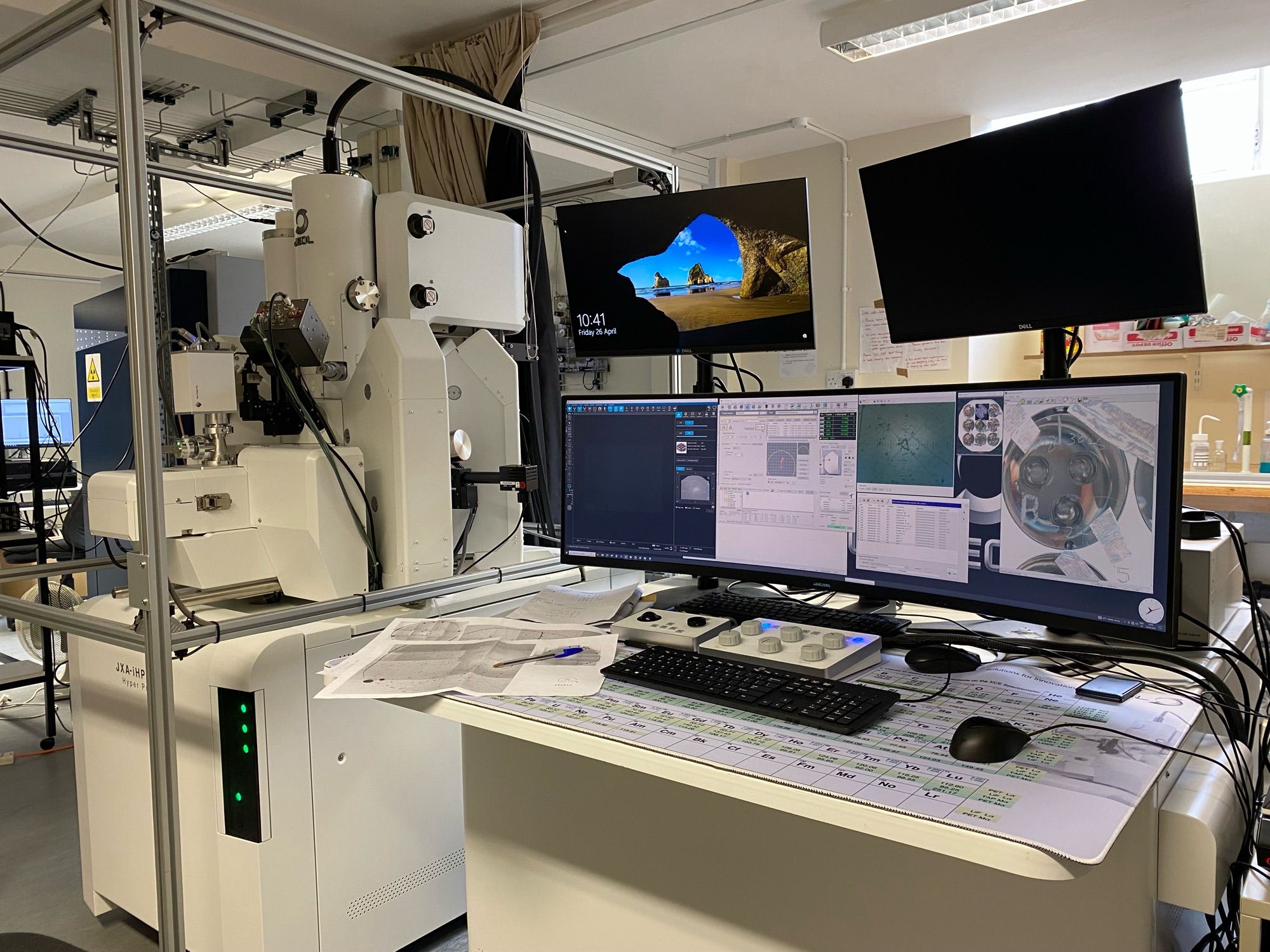 An electron microprobe, which looks like a large white machine in a metal cage and has lots of large computer monitors next to it.