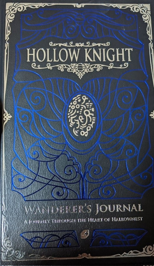 A game guide, in black, with silver and blue trim

Hollow Knight, very cool game